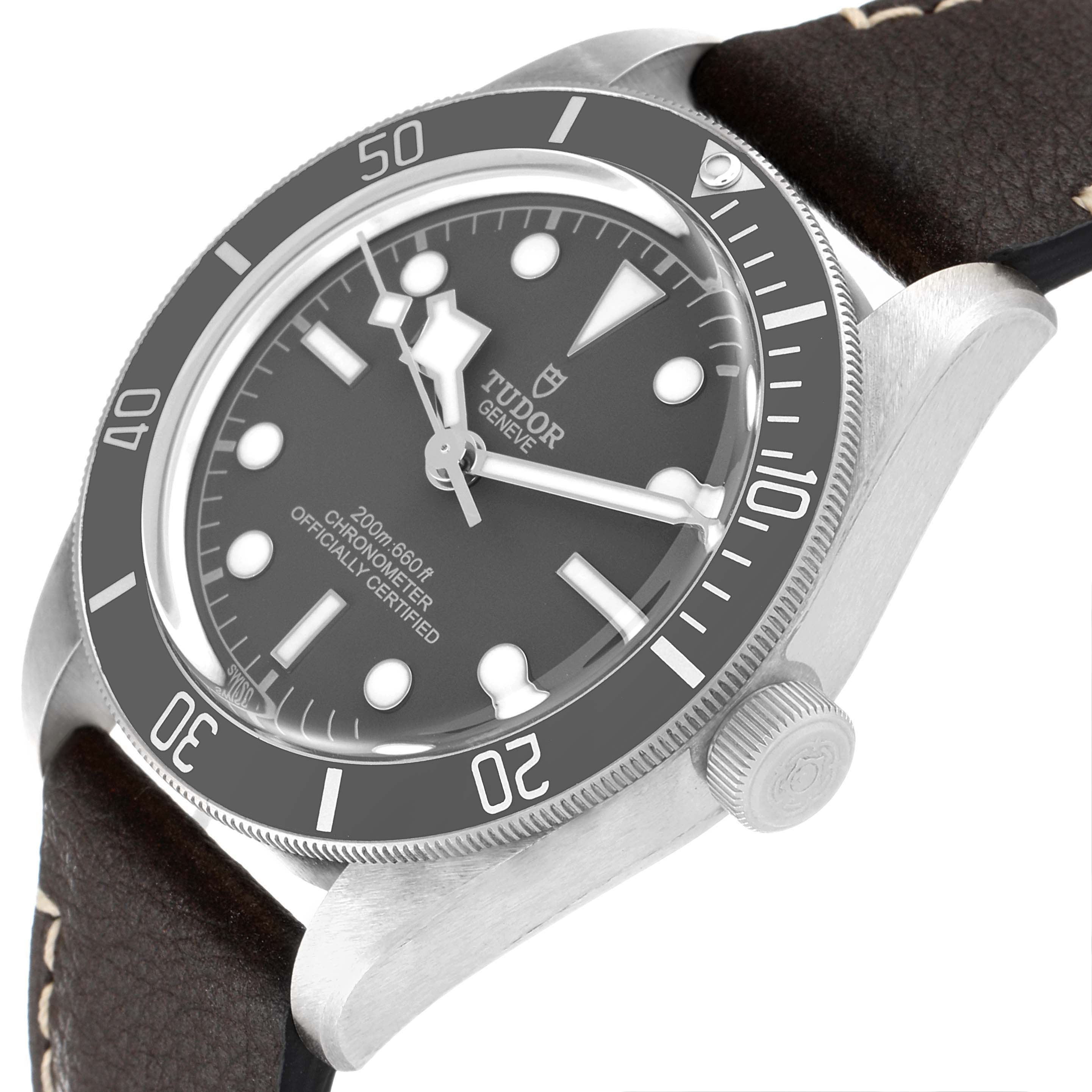 The image shows a Tudor Heritage Black Bay 79010SG Men's Stainless Steel Grey Dial 79010SG Men's Stainless Steel Grey Dial watch at an angled view highlighting the bezel, dial, crown, and leather strap.