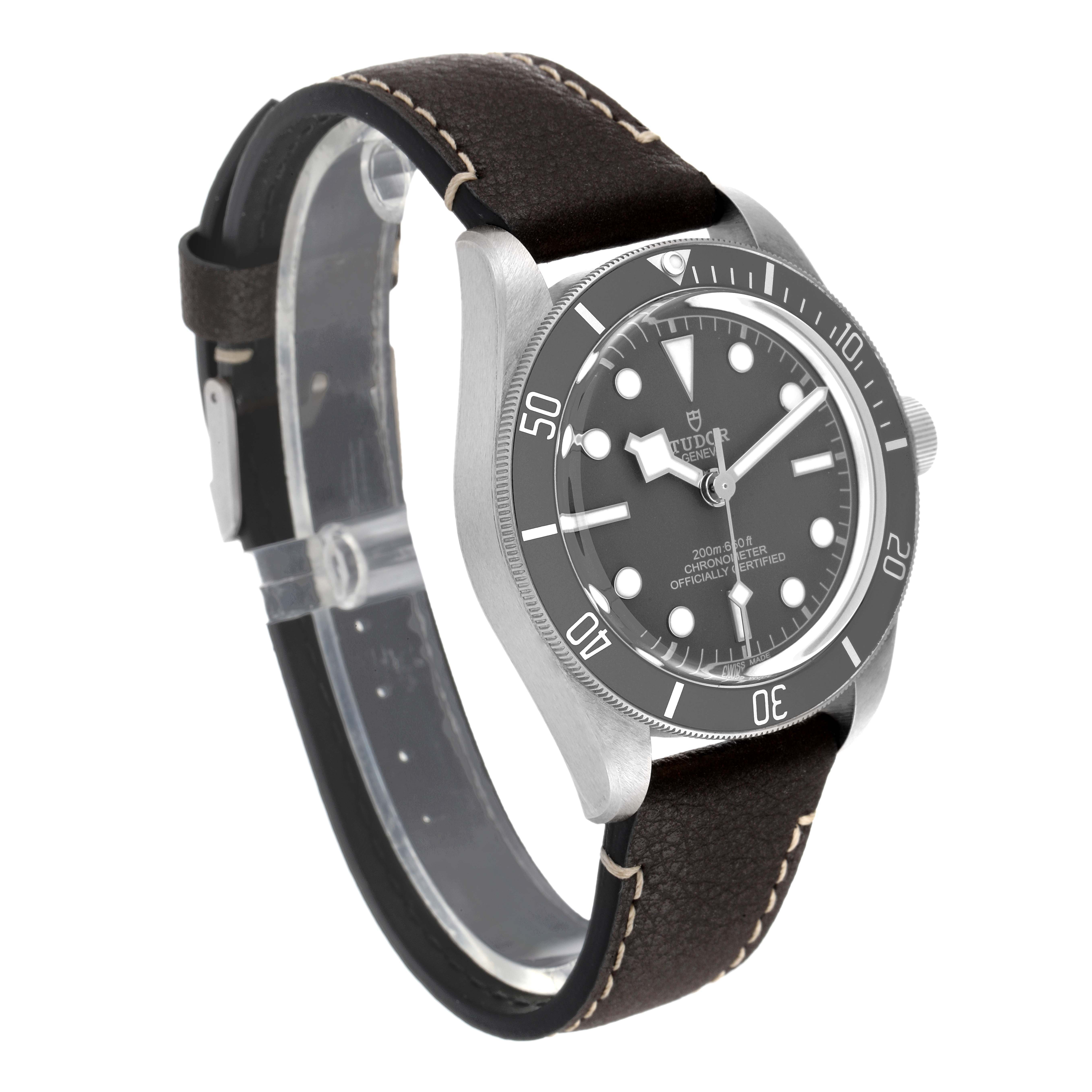 This image shows the Tudor Heritage Black Bay 79010SG Men's Stainless Steel Grey Dial 79010SG Men's Stainless Steel Grey Dial watch from a slight side angle, highlighting its face, bezel, crown, and leather strap.