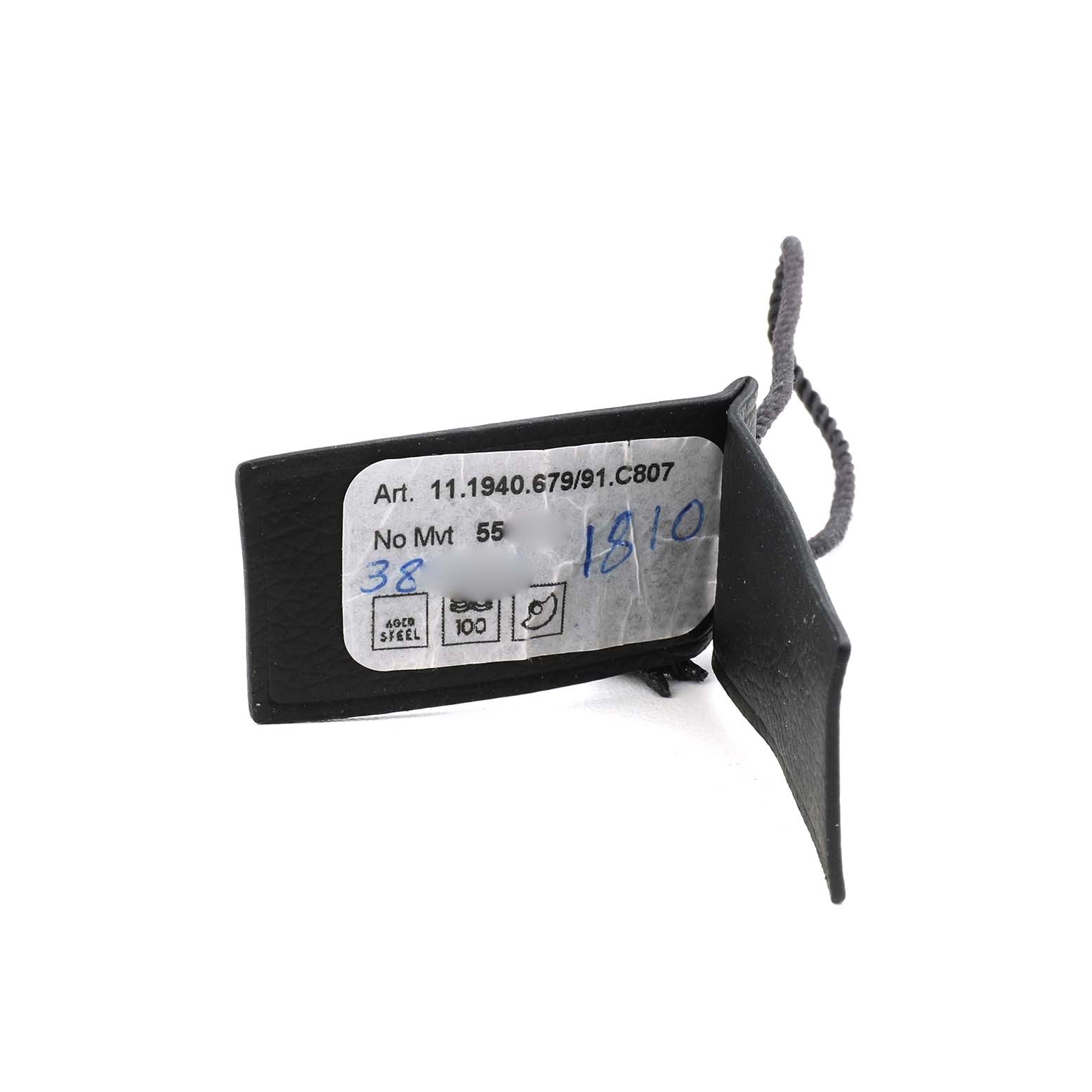 The image shows a tag with details of the Zenith Pilot 11.1940.679 Men's Stainless Steel Grey Dial model watch, including reference numbers and materials.