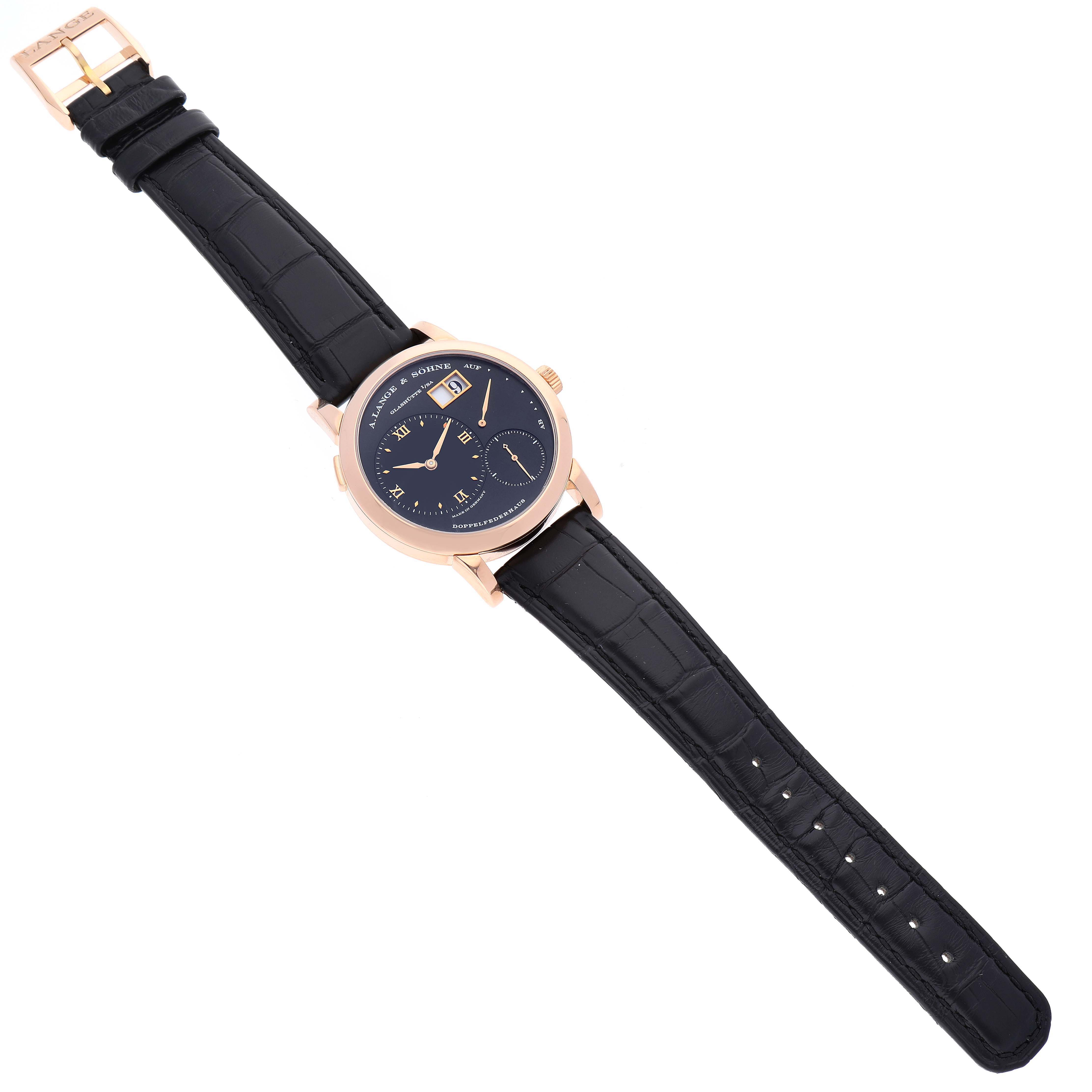 The Lange 1 model by A. Lange & Söhne is shown from a top-down angle, displaying the watch face, straps, and buckle in full view.