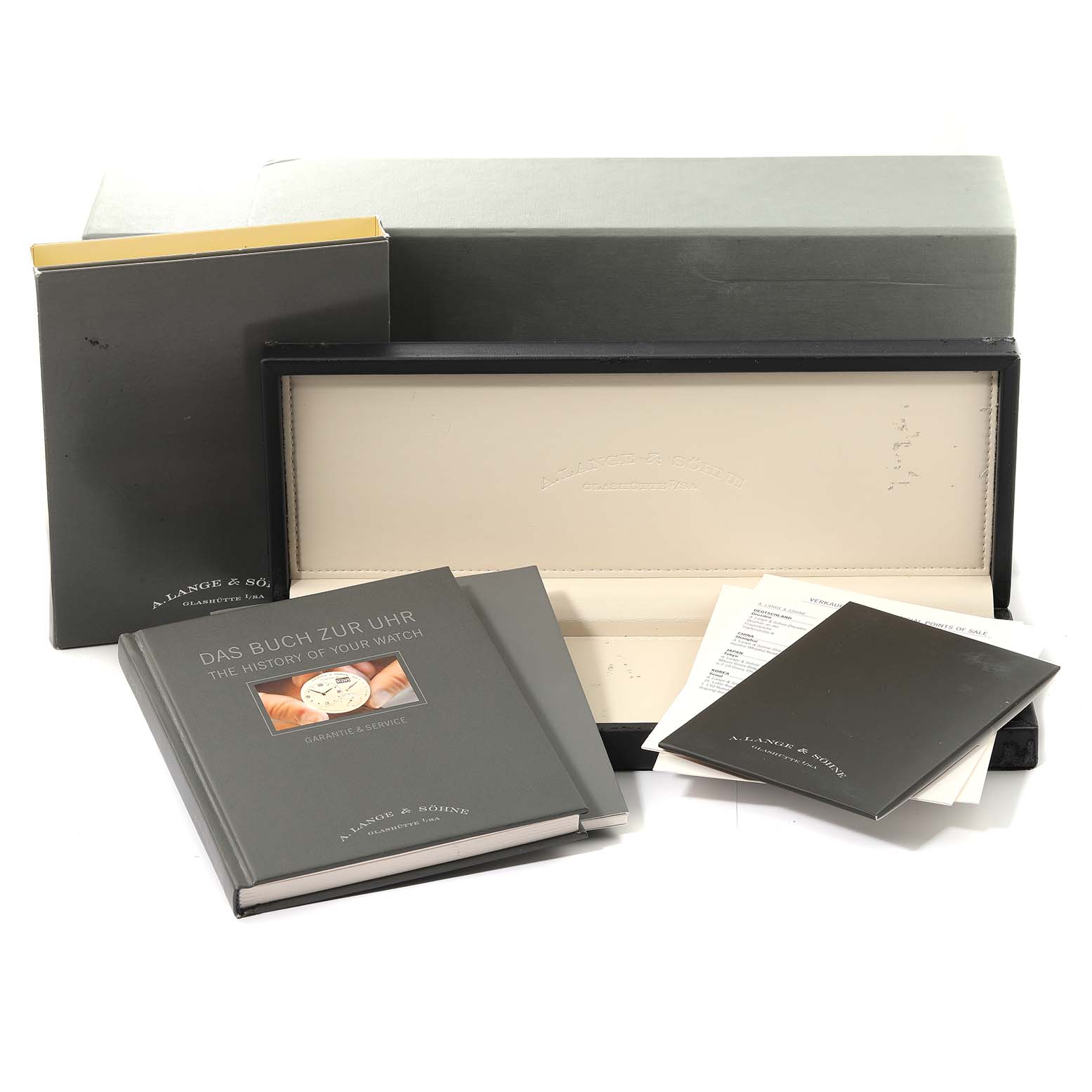 The image shows the packaging, booklets, and watch case for the A. Lange & Sohne 1815 model.