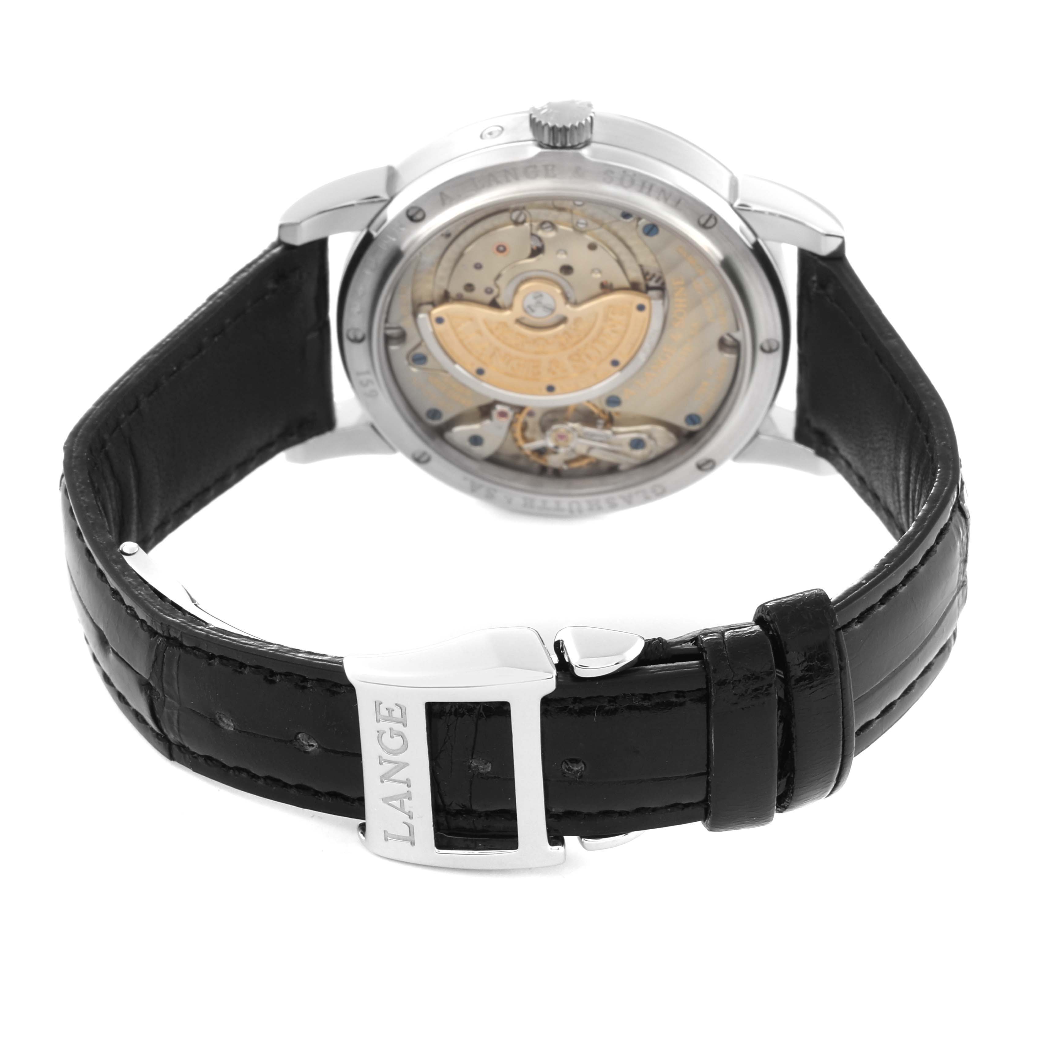 The image shows the back view of the A. Lange & Sohne Richard Lange 310.025E/LS3102AP Men's Platinum Silver Dial watch, highlighting its movement and black leather strap.