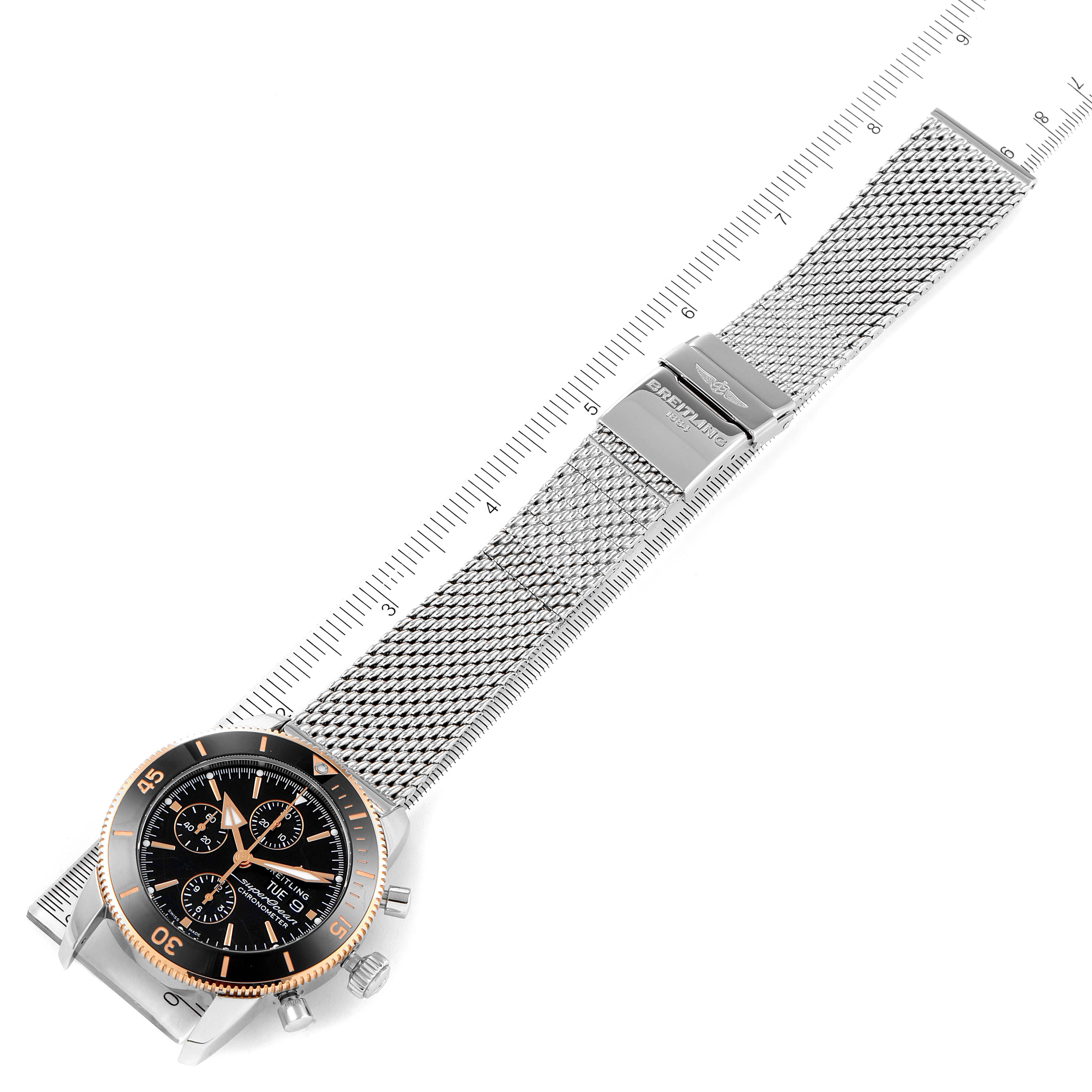 The image shows a top-down view of a Breitling Superocean U13313121B1A1 Men's Steel and Gold (two tone) Black Dial U13313121B1A1 Men's Steel and Gold (two tone) Black Dial watch, focusing on the stainless steel mesh bracelet and clasp.