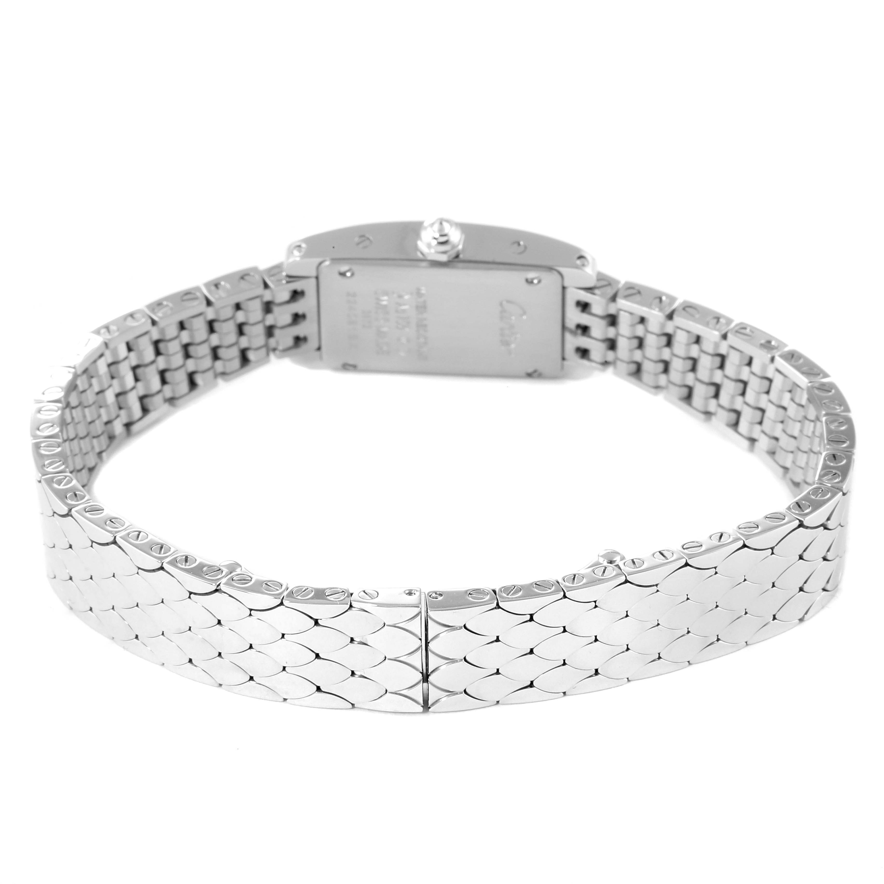 The image shows the back and clasp of a Tank Americaine watch by Cartier, highlighting its intricate metal bracelet design.
