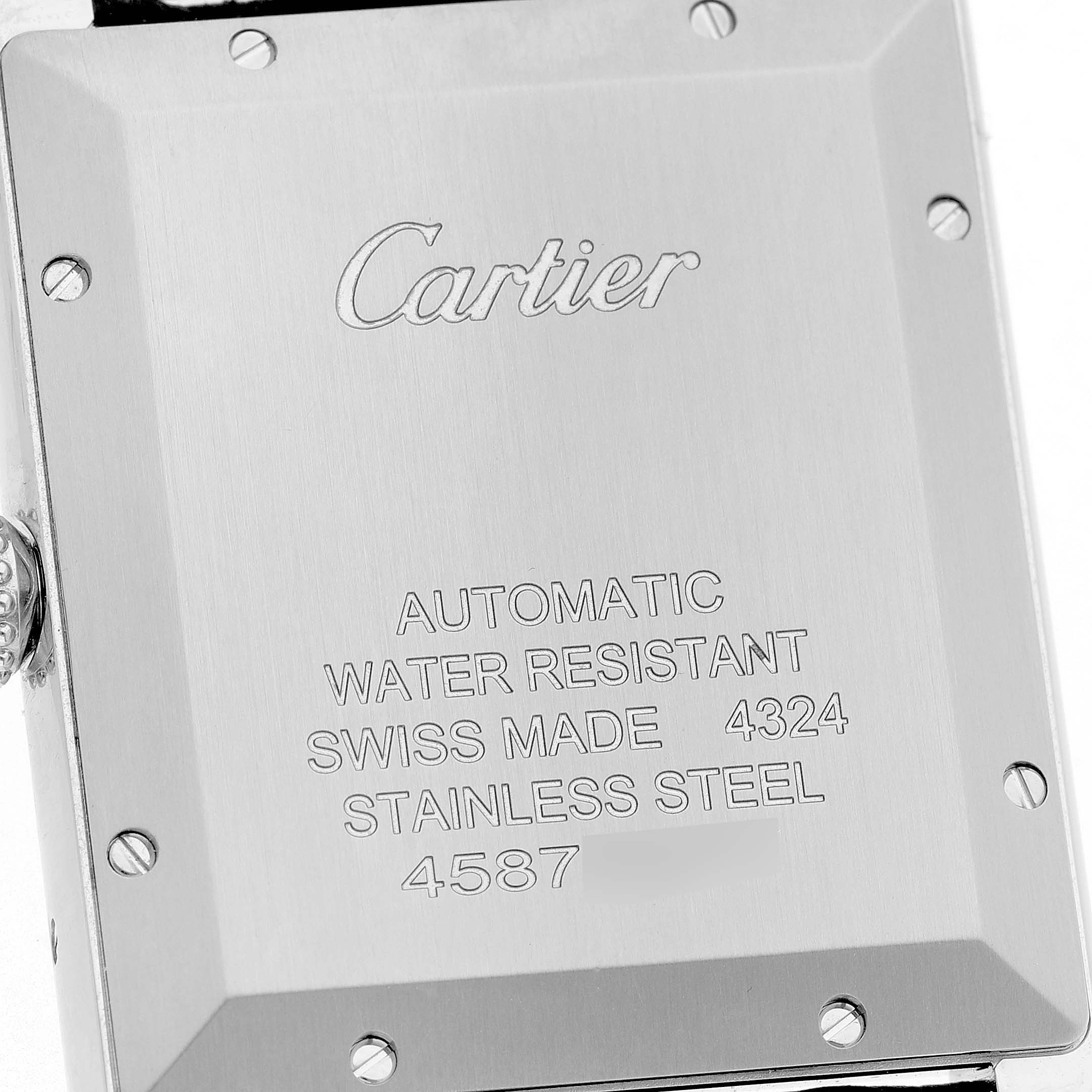 The image shows the back of the Cartier Tank Must WSTA0141 Men's Stainless Steel Silver Dial watch, highlighting the engraved details and material.