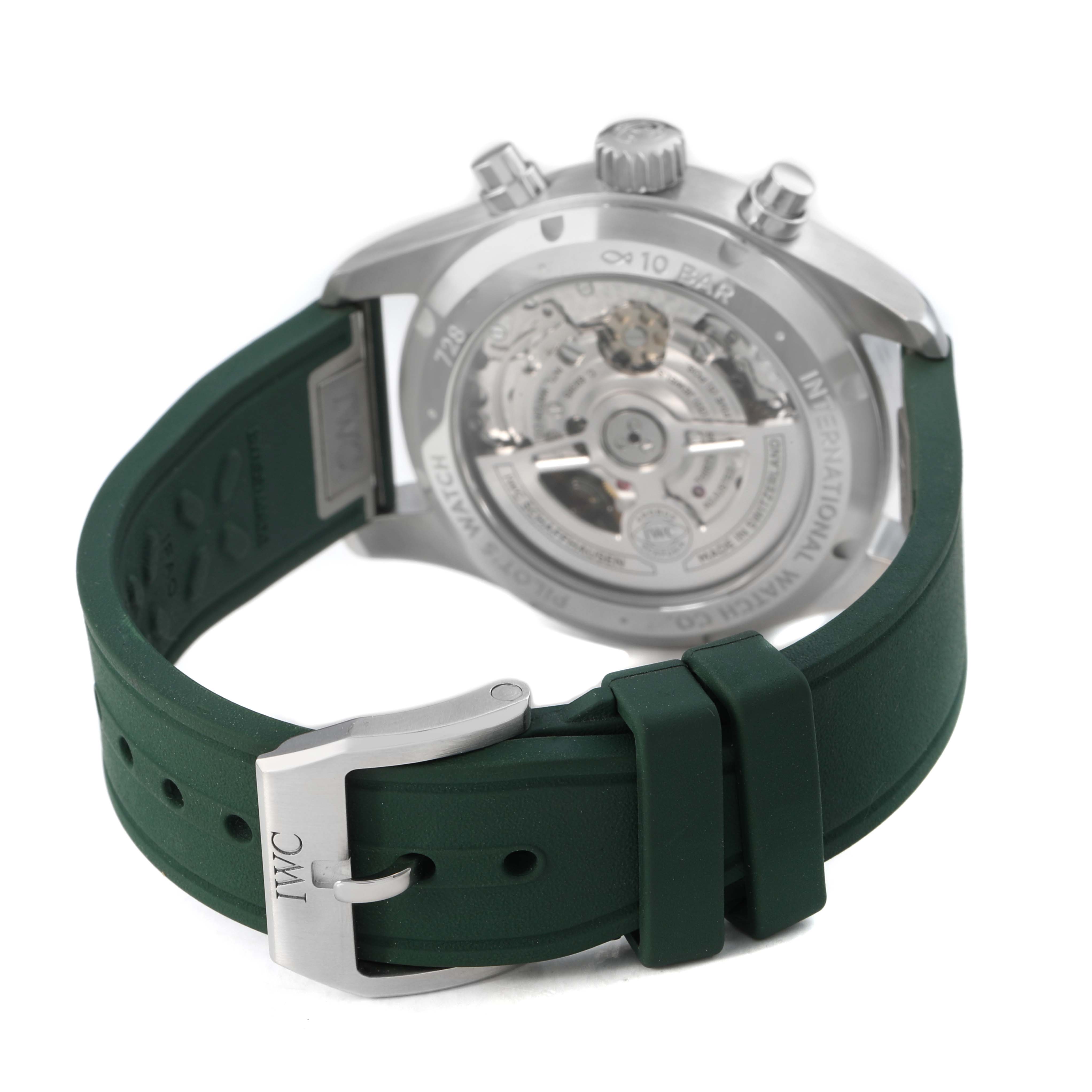 The IWC Pilot IW388103 Men's Stainless Steel Green Dial watch is shown from the back, highlighting the movement through the transparent case back and featuring a green strap with a branded buckle.