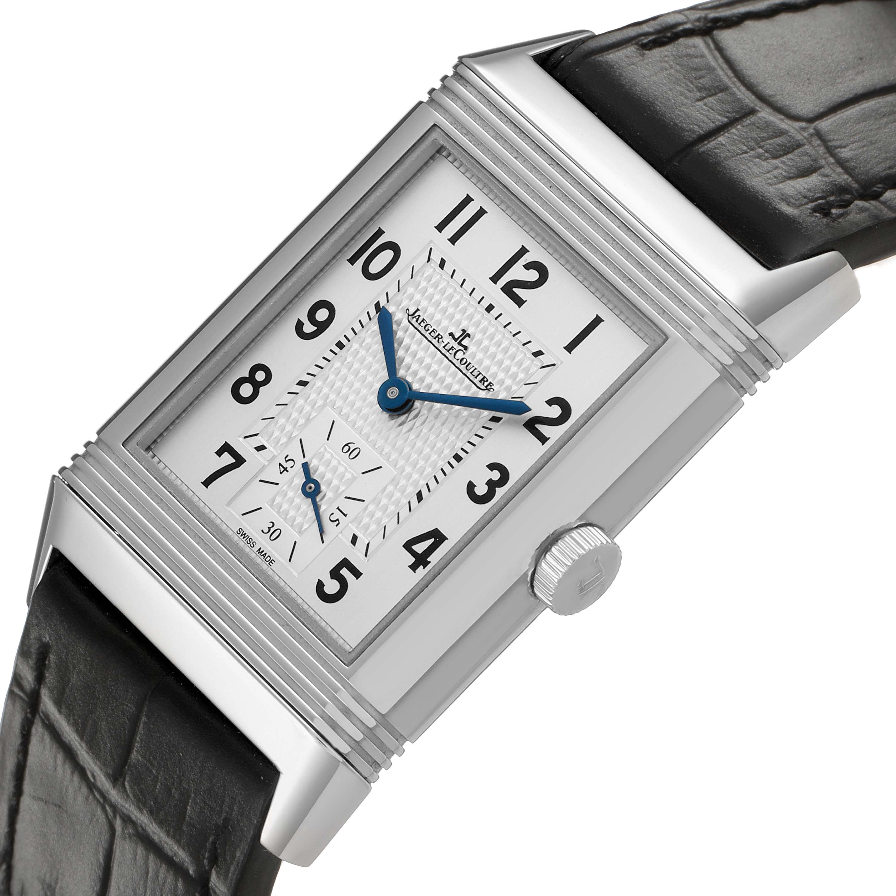 The Jaeger-LeCoultre Reverso watch is shown from a front angle, displaying its rectangular face, crown, and leather strap.