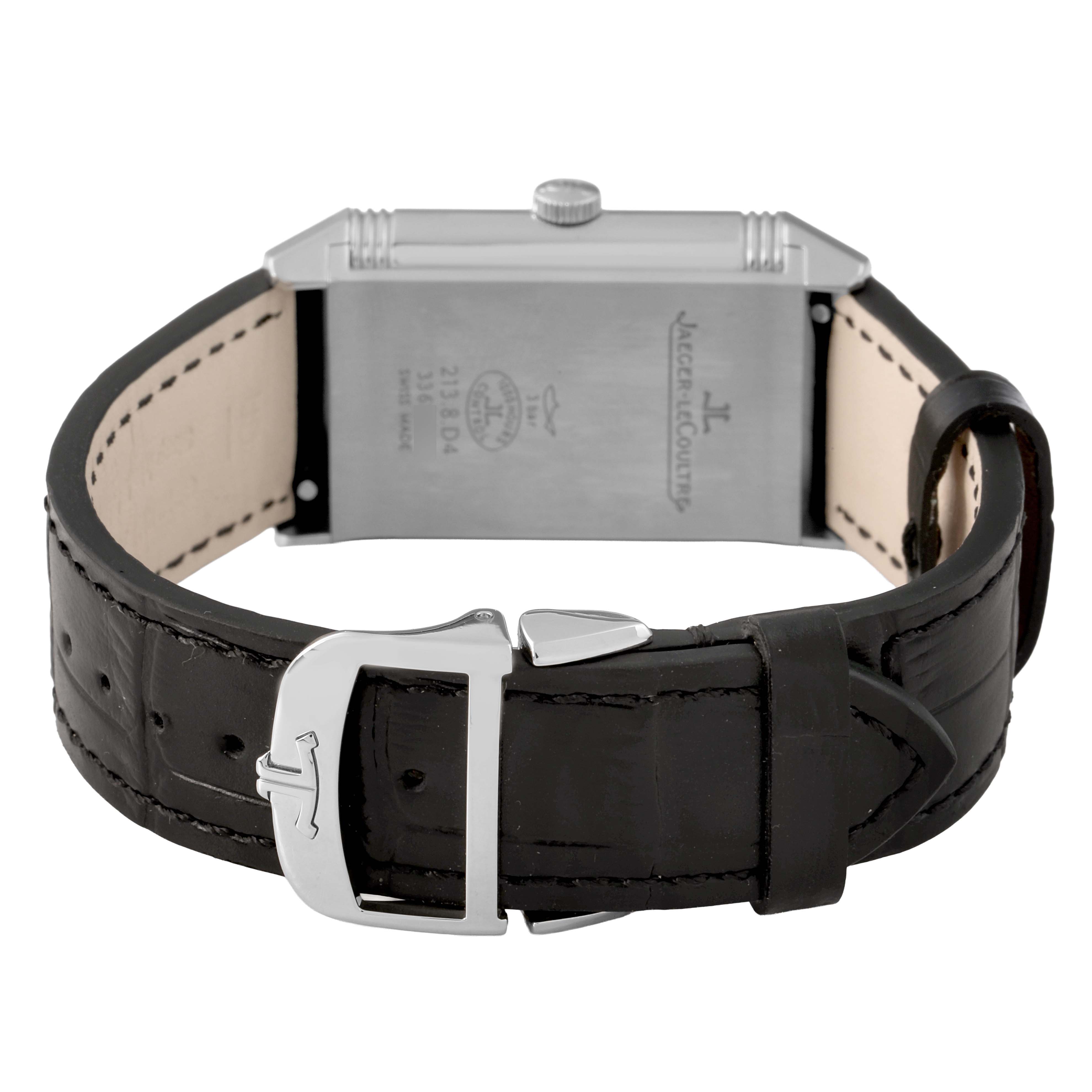 The image shows a Jaeger-LeCoultre Reverso watch from the back, highlighting the watch case, strap, and buckle.