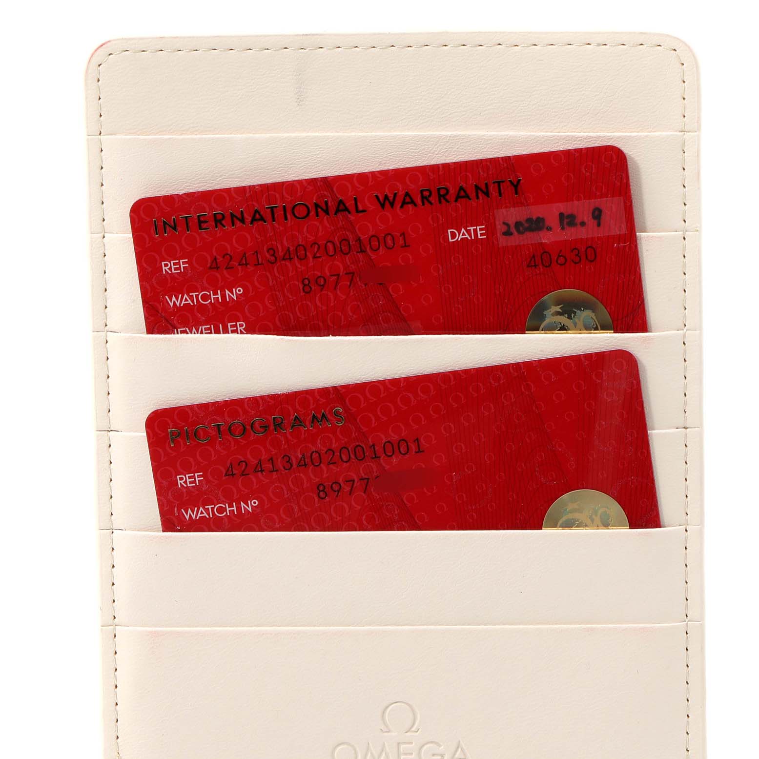 This image shows the international warranty cards for the Omega De Ville 424.13.40.20.01.001 Men's Stainless Steel Black Dial 424.13.40.20.01.001 Men's Stainless Steel Black Dial watch stored in a white cardholder.