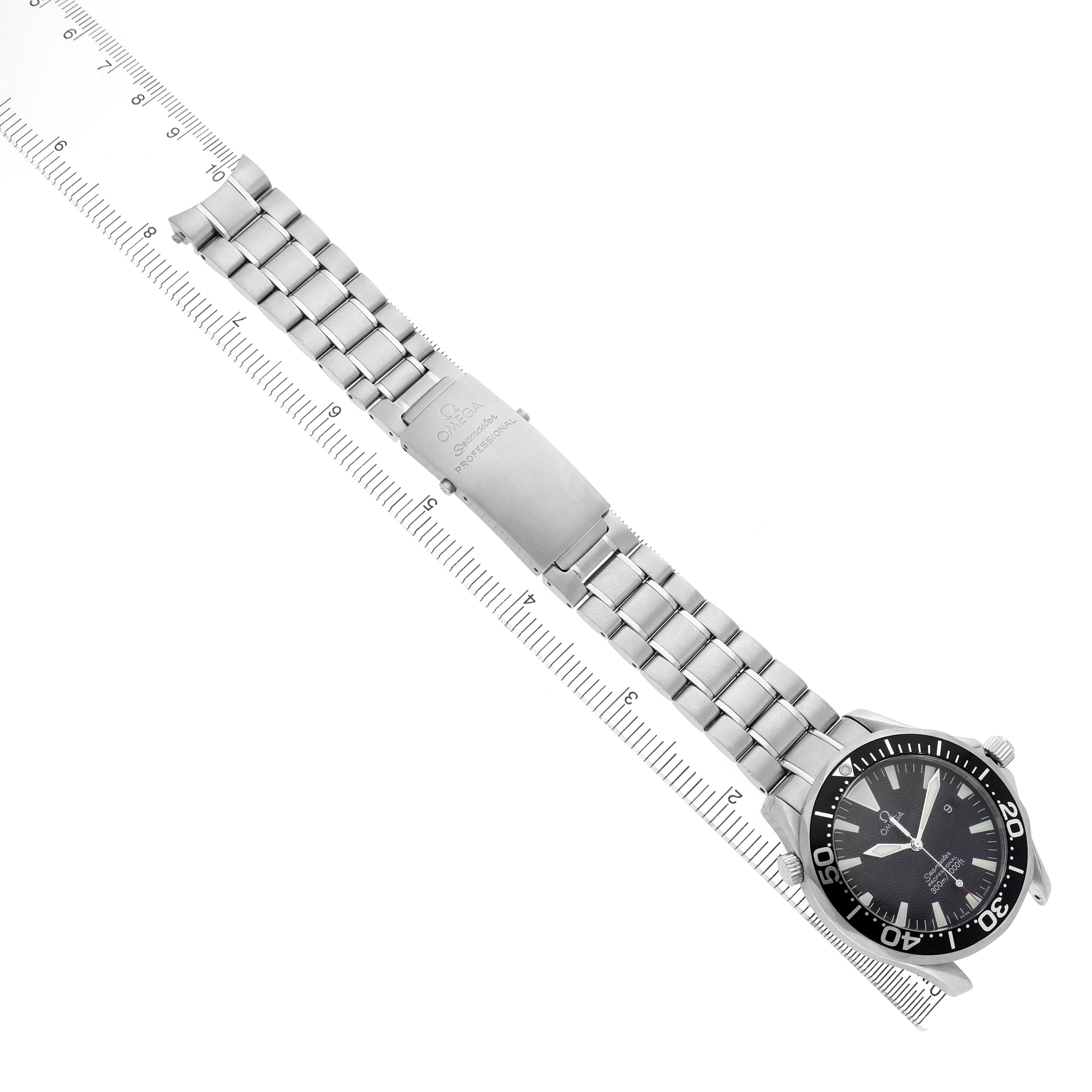 The Omega Seamaster 2264.50.00 Men's Stainless Steel Black Dial watch is displayed from a top-down angle, showcasing its face, stainless steel bracelet, and clasp alongside a ruler.