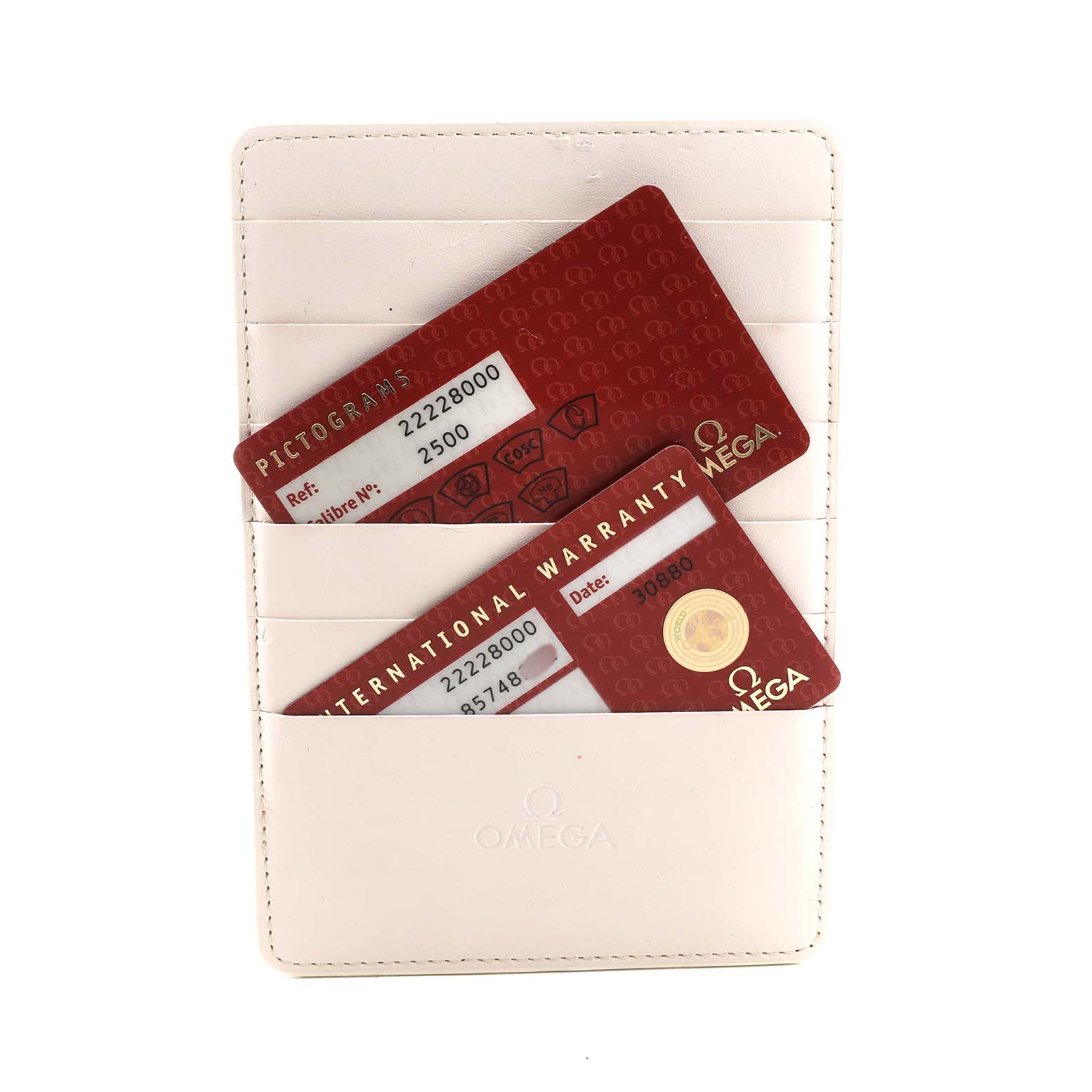 The image shows Omega warranty and pictogram cards for a Seamaster model in a white cardholder, viewed from above.