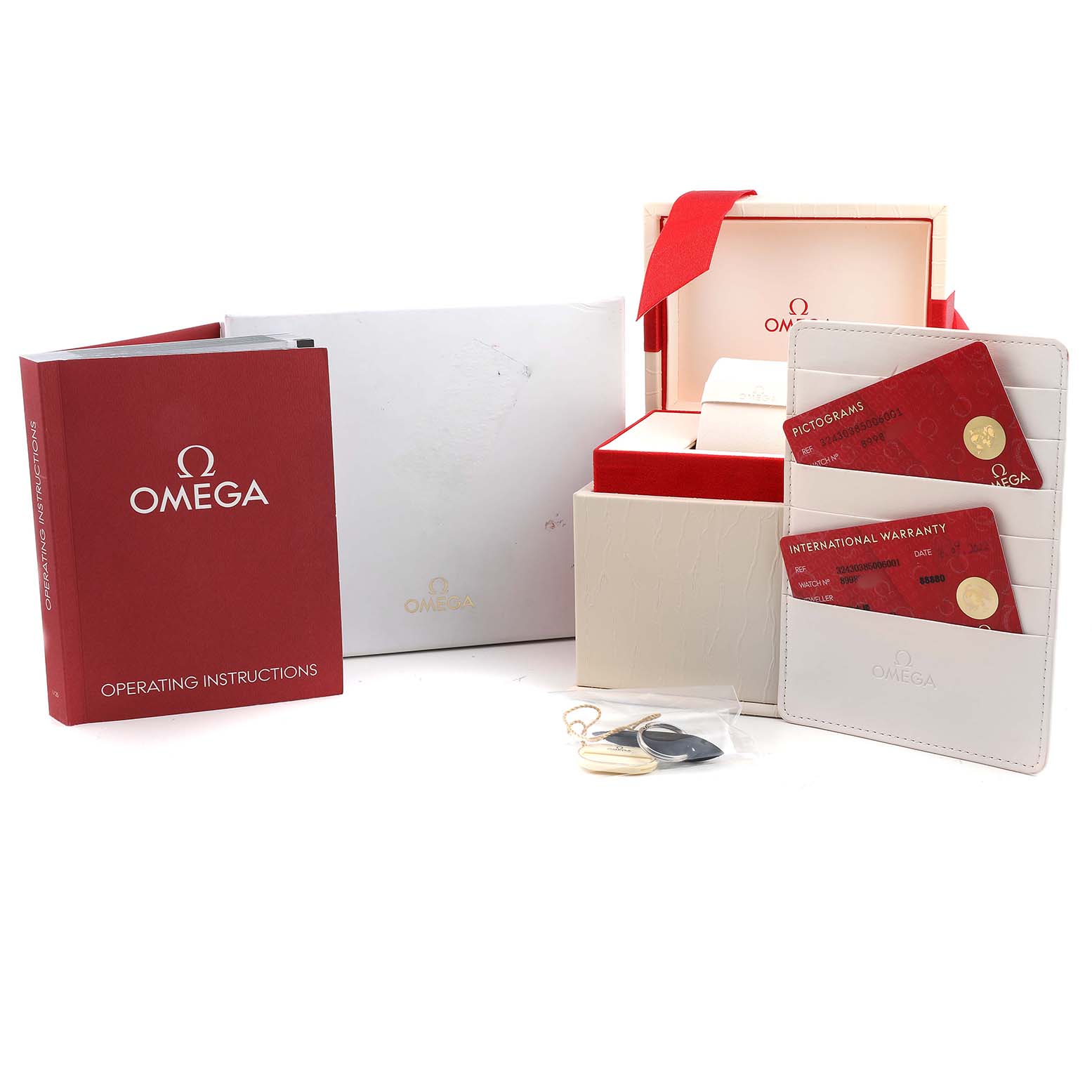 The image shows Omega Speedmaster 324.30.38.50.06.001 Men's Stainless Steel Grey Dial accessories, including a box, manual, warranty cards, and pictograms at a front-facing angle.