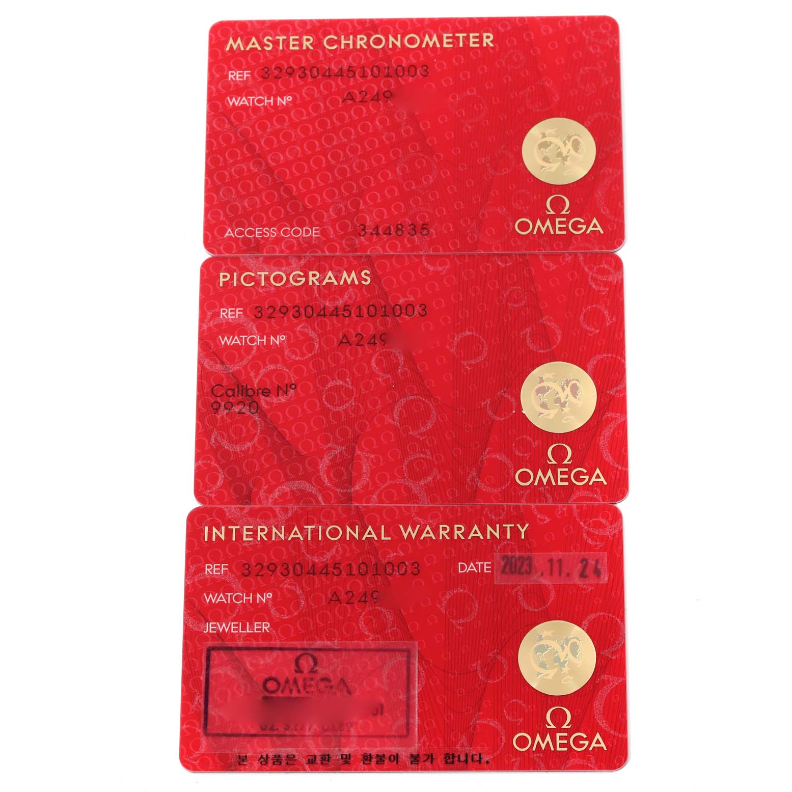 This image shows three red Omega cards, labeled Master Chronometer, Pictograms, and International Warranty, likely for a Speedmaster model.