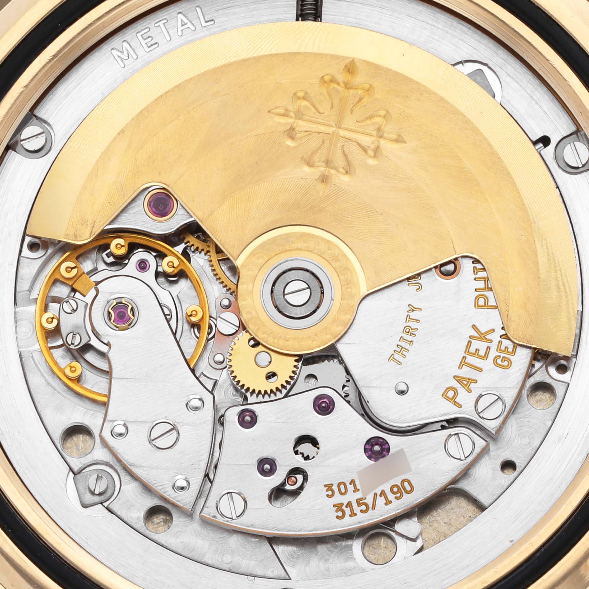 The image shows the internal mechanism of a Patek Philippe Aquanaut 5065J Men's Yellow Gold Black Dial 5065J Men's Yellow Gold Black Dial watch at a close-up angle, highlighting its rotor and gears.
