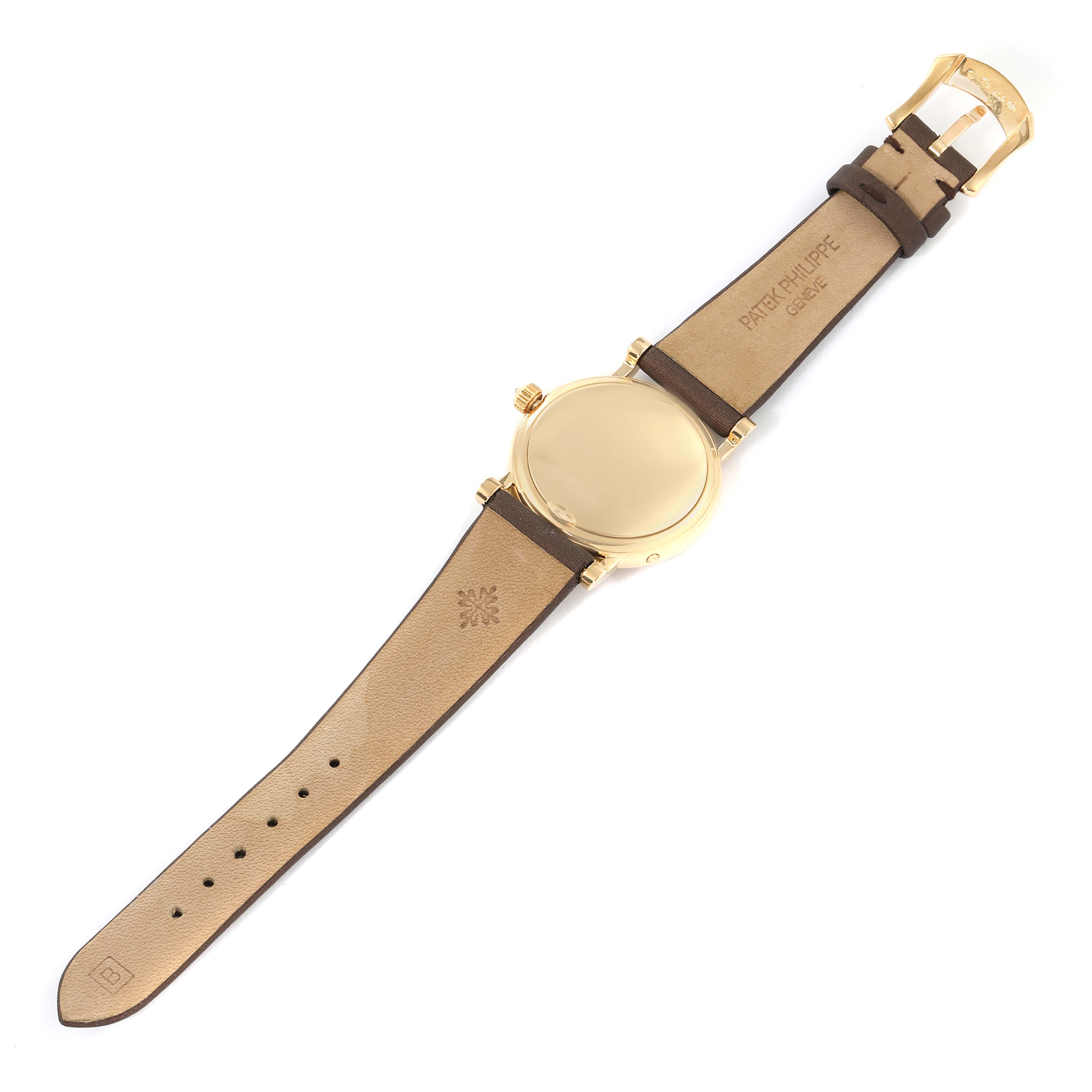 The image shows the back and strap of a Patek Philippe Calatrava 4858J-010 Women's Yellow Gold Brown Dial 4858J-010 Women's Yellow Gold Brown Dial watch laid flat, showcasing the gold case and brown leather strap.