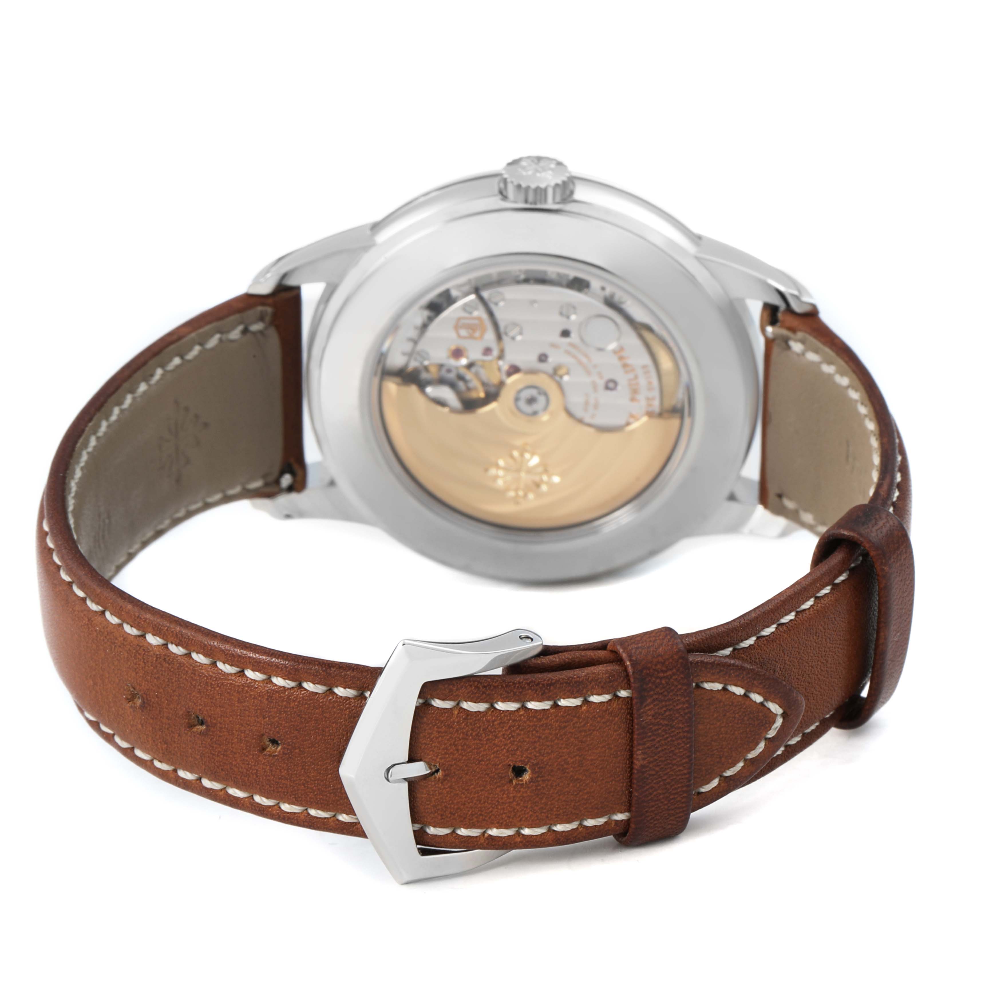 The Patek Philippe Complications 5212A-001 Men's Stainless Steel Silver Dial watch is shown from the back, displaying its movement and brown leather strap.