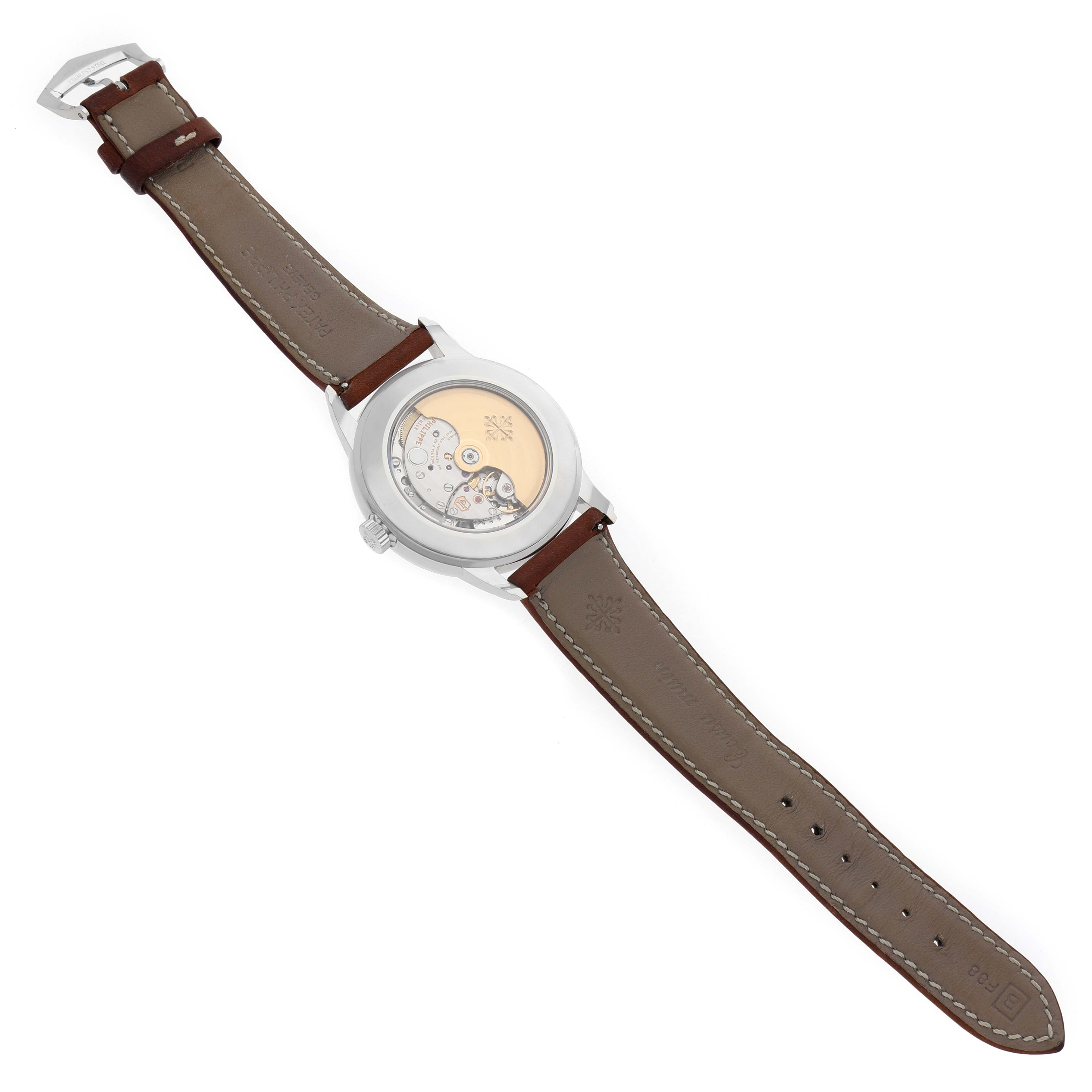 The Patek Philippe Complications 5212A-001 Men's Stainless Steel Silver Dial watch is shown from the back, displaying its exposed movement and brown leather strap.