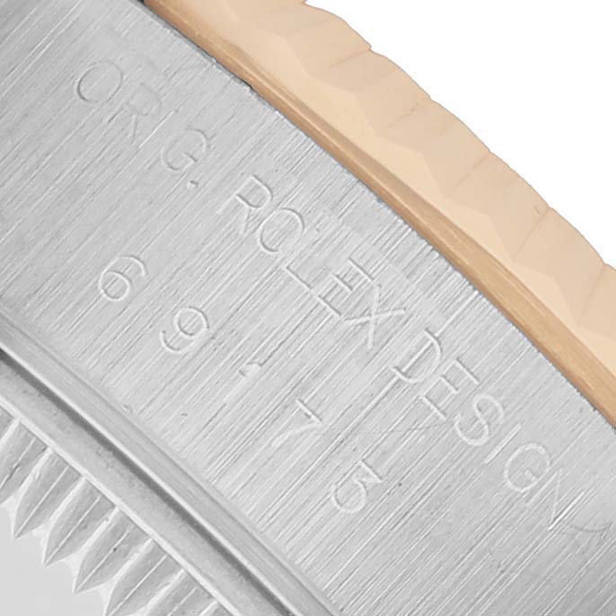 The image shows a close-up of the case edge of a Rolex Datejust 69173 Women's Steel and Gold (two tone) Black Dial, highlighting the engraved details.
