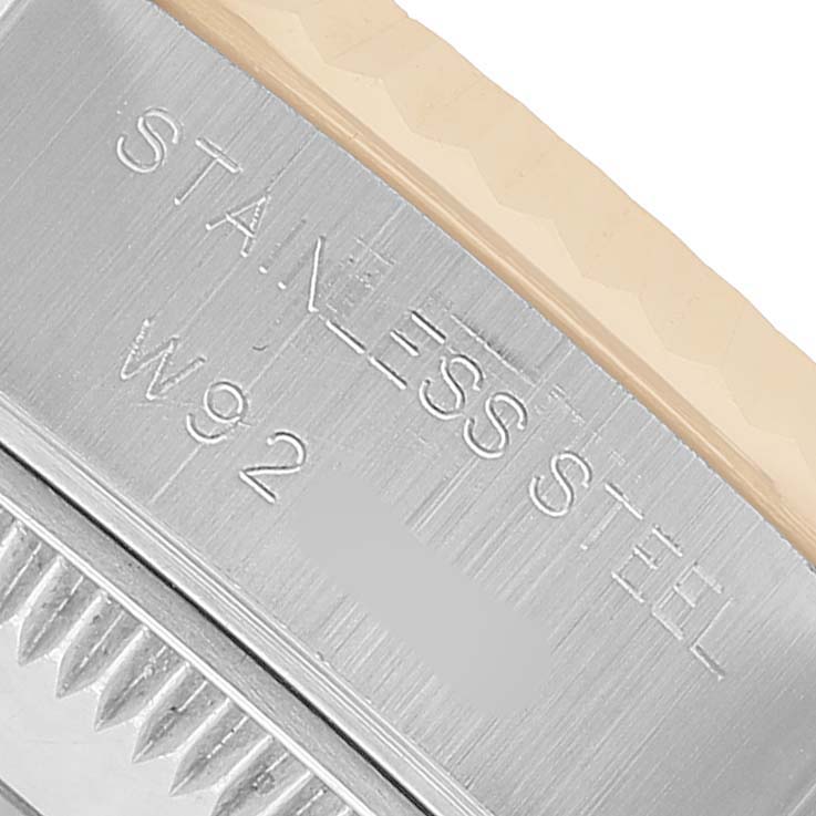 The image shows a close-up angle of the case edge of a Rolex Datejust 69173 Women's Steel and Gold (two tone) Black Dial, highlighting the stainless steel engraving and fluted bezel.