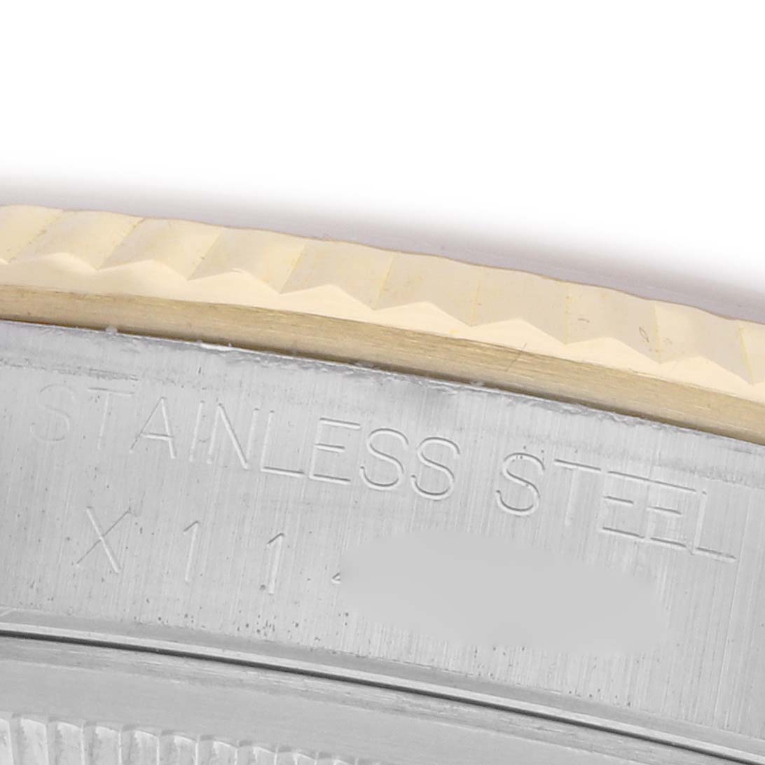 The image shows a close-up of the Rolex Datejust 16233 Men's Steel and Gold (two tone) Champagne Dial 16233 Men's Steel and Gold (two tone) Champagne Dial's stainless steel watch case with visible text engraving.