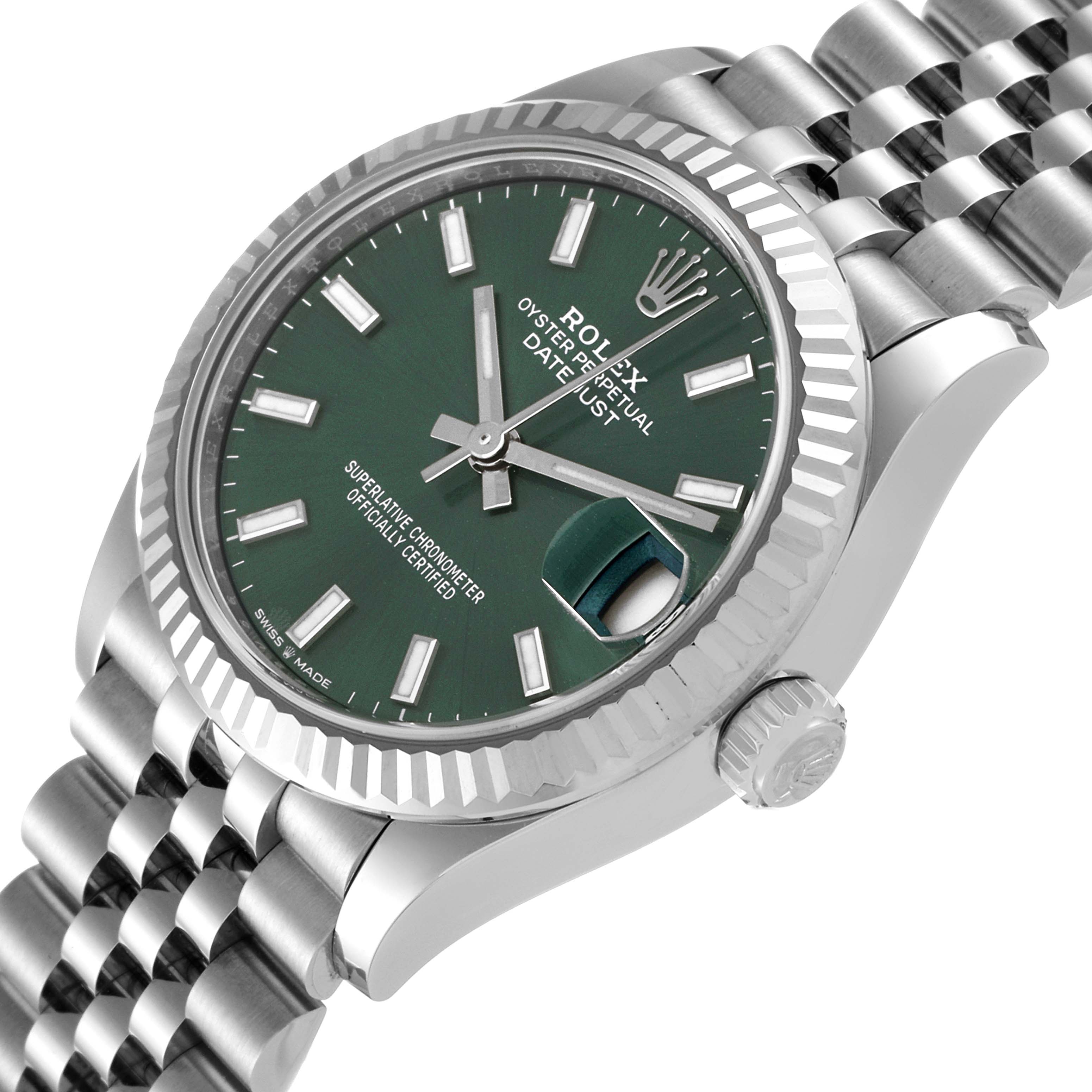 The Mid-Size Rolex watch is shown from a tilted side angle, featuring a green dial, fluted bezel, and Jubilee bracelet.