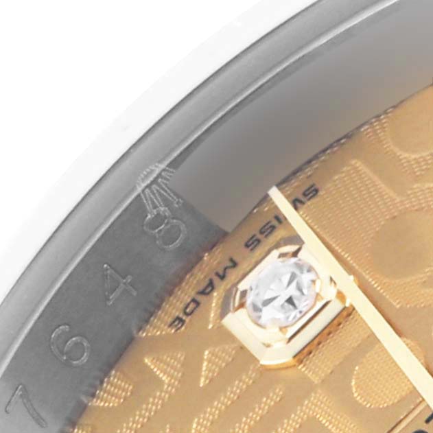 The image shows a close-up of a Rolex Datejust 116233 Men's Steel and Gold (two tone) Champagne Dial 116233 Men's Steel and Gold (two tone) Champagne Dial watch's bezel and part of its dial with a diamond hour marker.