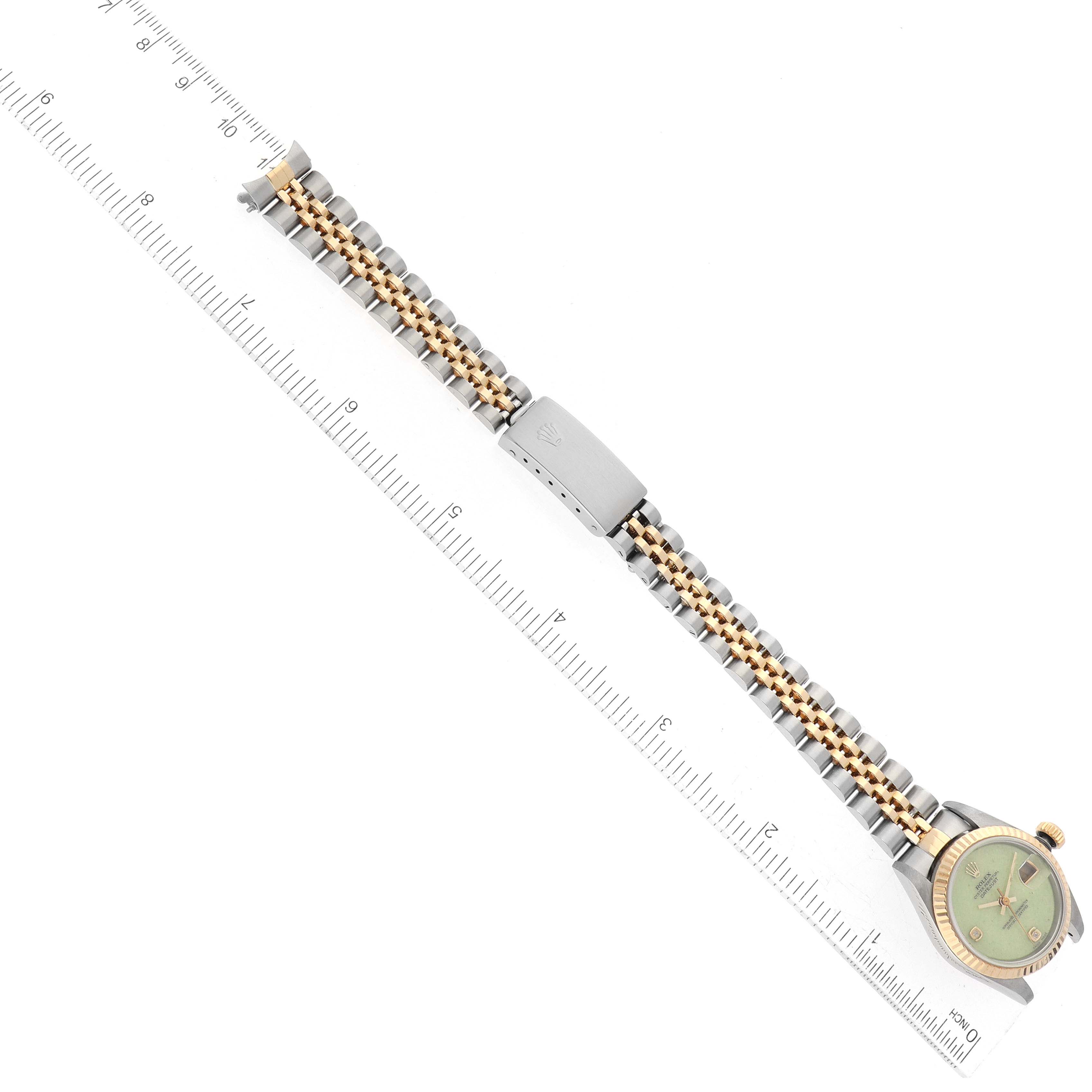 This image shows a Rolex Datejust 79173 Women's Steel and Gold (two tone) Green Dial 79173 Women's Steel and Gold (two tone) Green Dial watch from a top-down angle, including the entire band and part of the face.