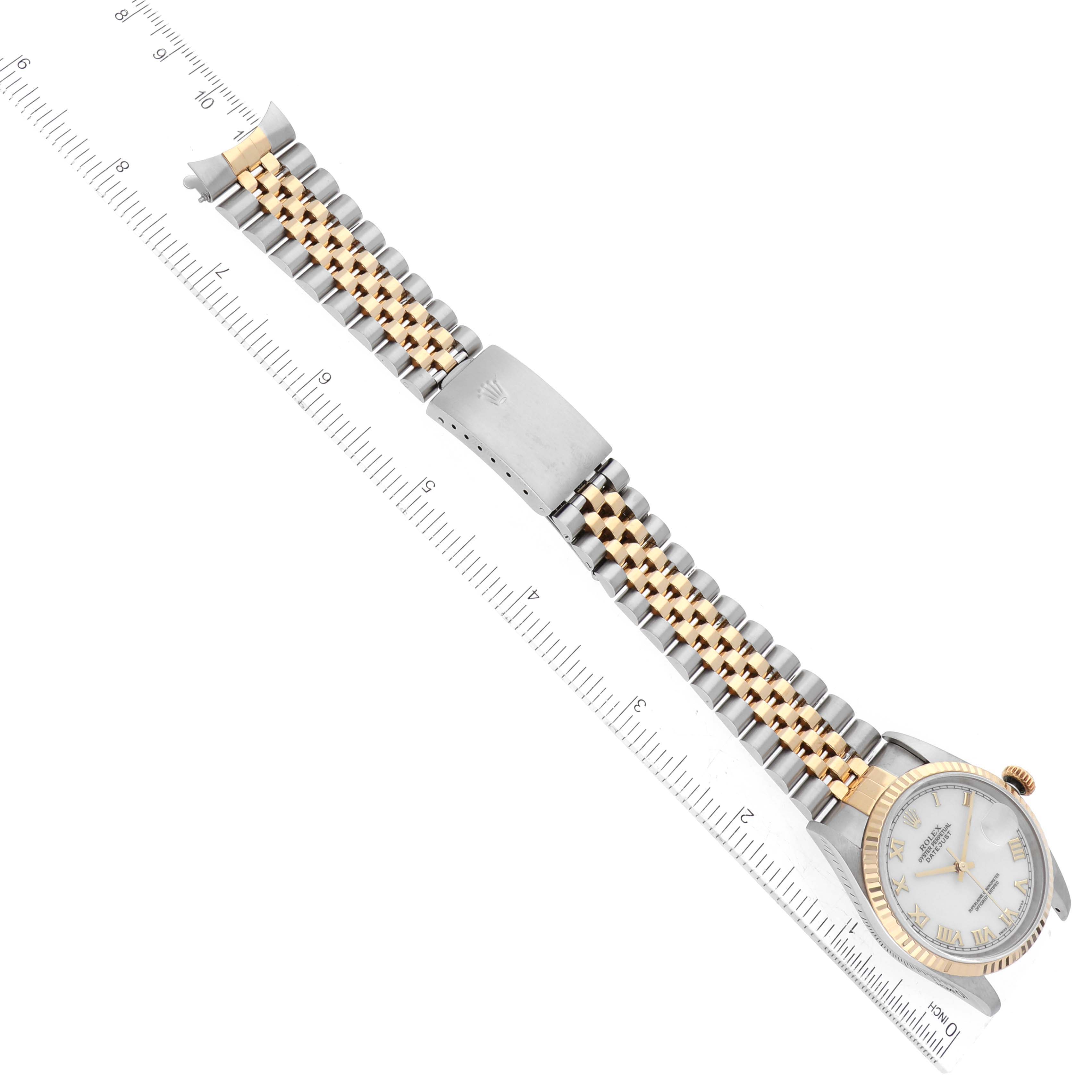 The image shows a top-down view of a Rolex Datejust 16233 Men's Steel and Gold (two tone) White Dial 16233 Men's Steel and Gold (two tone) White Dial watch with a two-tone bracelet and a ruler for measuring.