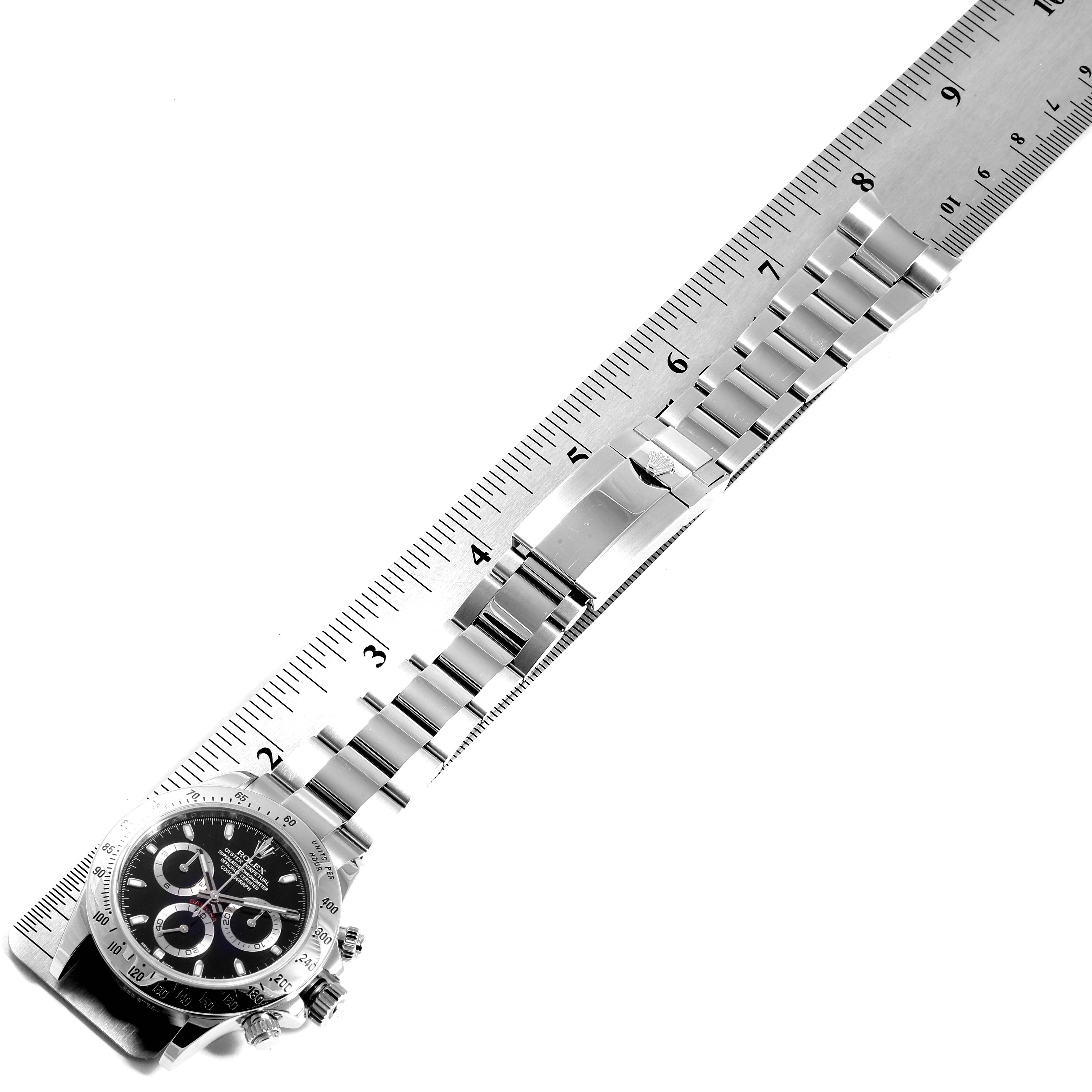 The image shows a Rolex Daytona 116520 Men's Stainless Steel Black Dial 116520 Men's Stainless Steel Black Dial watch laid out flat, with the face and bracelet on a ruler for scale.