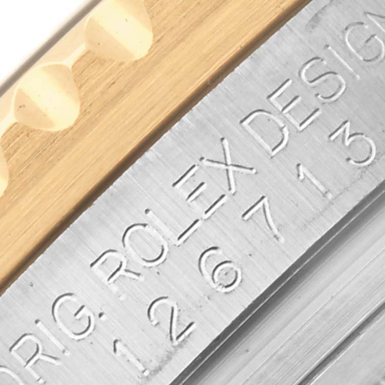 The image shows a close-up of the side engraving on the bezel and case of a Rolex GMT-Master 126713GRNR Men's Steel and Gold (two tone) Black Dial 126713GRNR Men's Steel and Gold (two tone) Black Dial watch.