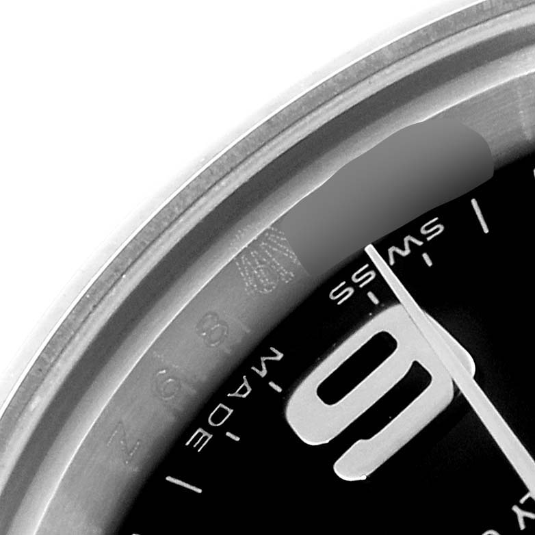 This close-up image of the Rolex Oyster Perpetual 176200 Women's Stainless Steel Black Dial 176200 Women's Stainless Steel Black Dial watch shows part of the bezel, the dial with the number '9' and the 'Swiss Made' marking.