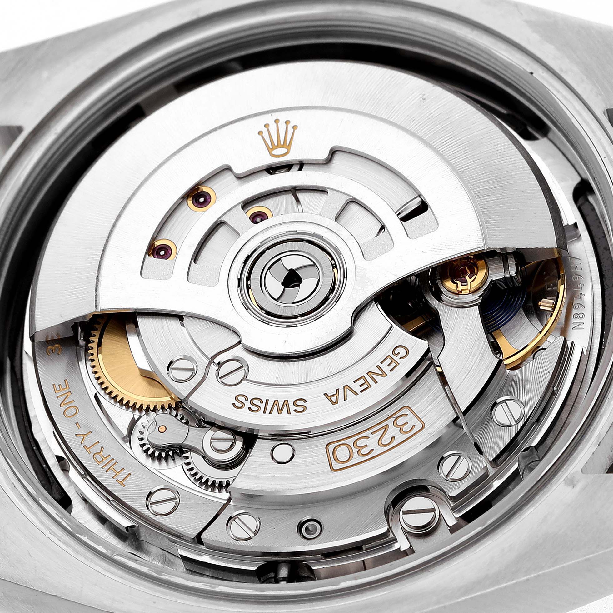 The image shows the movement of a Rolex Oyster Perpetual 7594Z726 Men's Stainless Steel Black Dial, highlighting gears, rotor, and intricate mechanical components from a top-down angle.