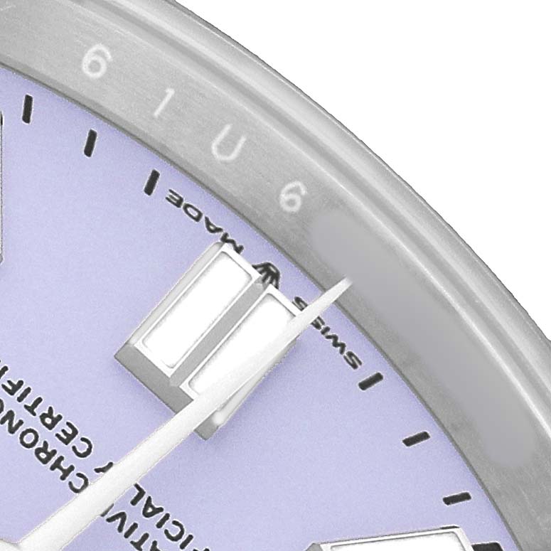 The image shows a close-up of the dial and bezel of a Rolex Oyster Perpetual 134300 Men's Stainless Steel Blue Dial watch, highlighting the indices and hands.