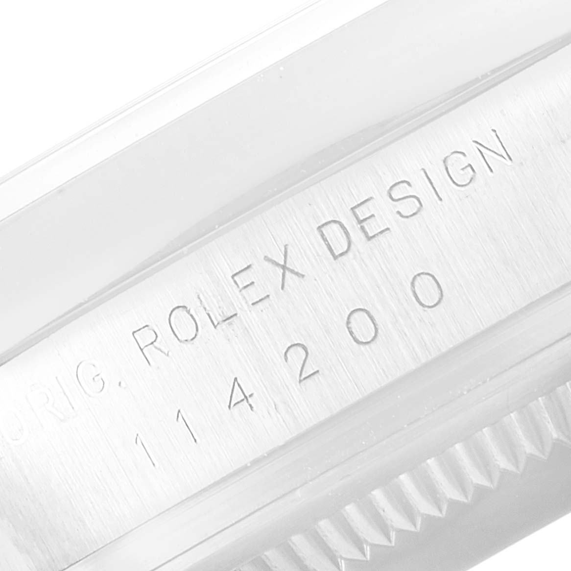 This image shows a close-up of the engraving on the side of the bezel of a Rolex Oyster Perpetual 114200 Men's Stainless Steel Black Dial 114200 Men's Stainless Steel Black Dial watch.