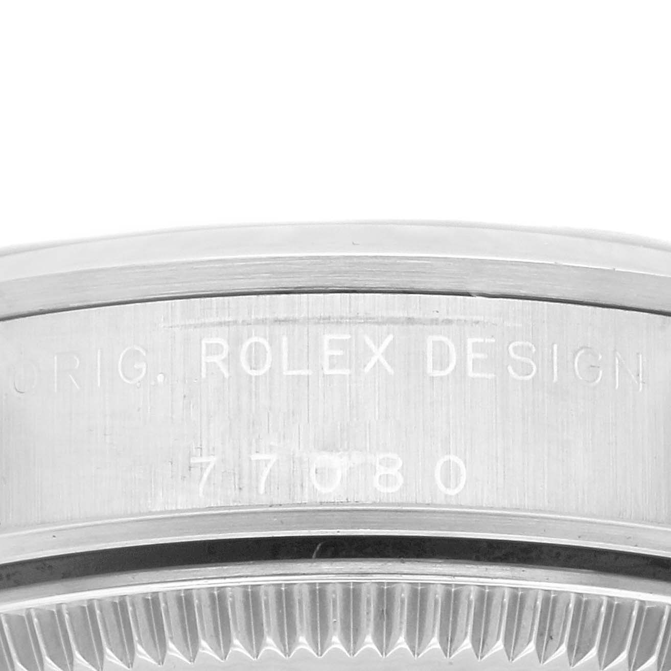 The image shows a close-up of the side of a Rolex Mid-Size 77080 Women
s Stainless Steel Silver Dial 77080 Women
s Stainless Steel Silver Dial model watch, highlighting engraved text and part of the bezel.