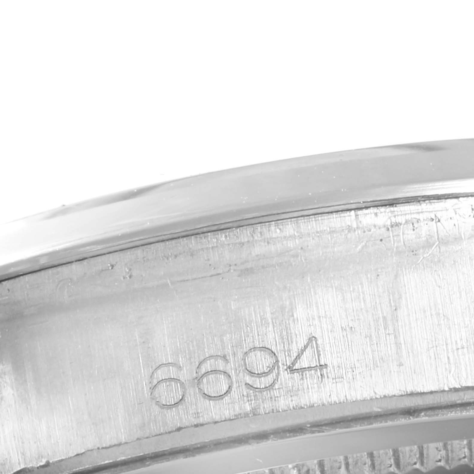 This is a close-up of the serial number "6694" engraved on the case of a Rolex Vintage Collection 6694 Men's Stainless Steel Champagne Dial 6694 Men's Stainless Steel Champagne Dial watch.