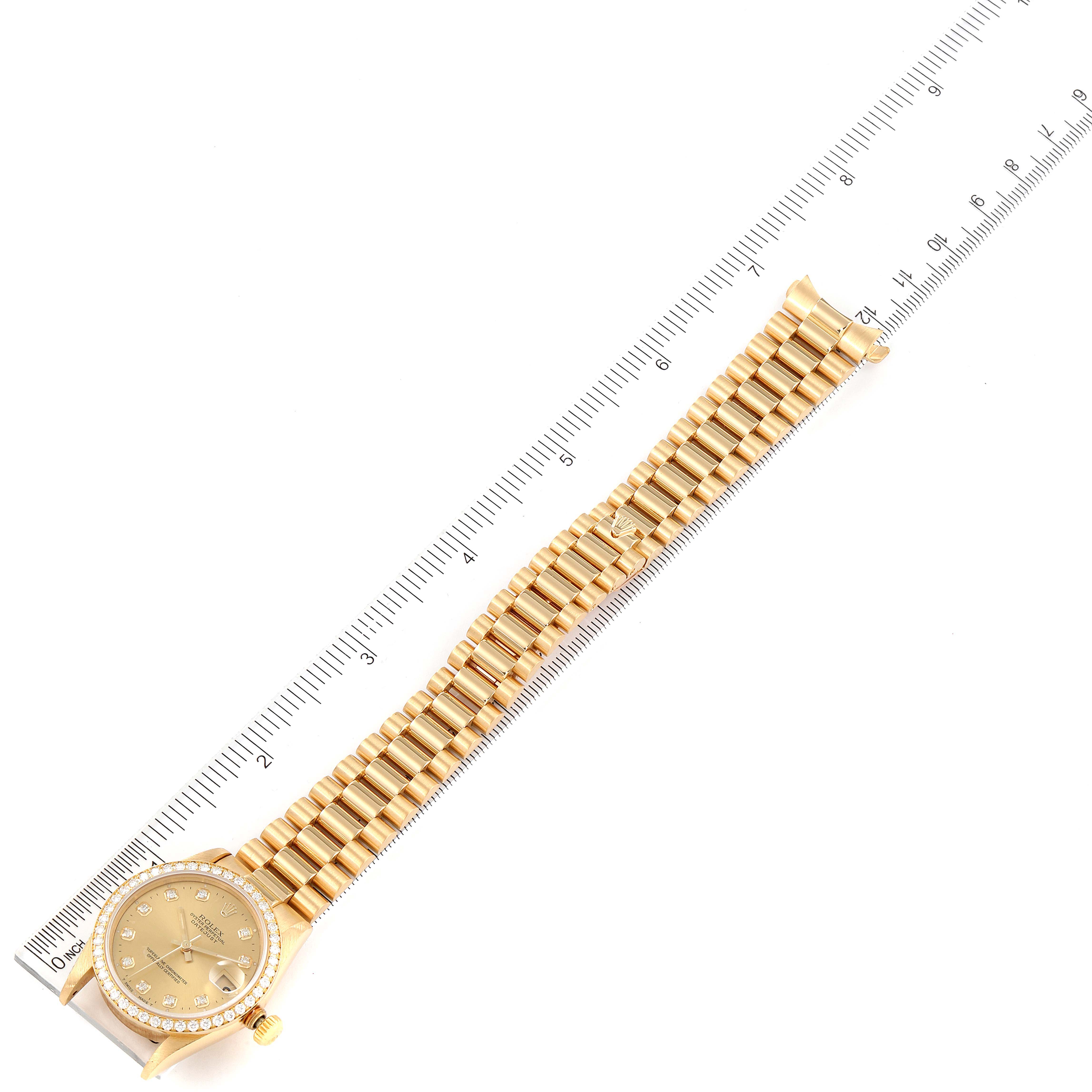 The image shows the full length of the Rolex President 68288 Women
s Yellow Gold Champagne Dial 68288 Women
s Yellow Gold Champagne Dial model watch, including the face and gold bracelet, with a ruler for scale.