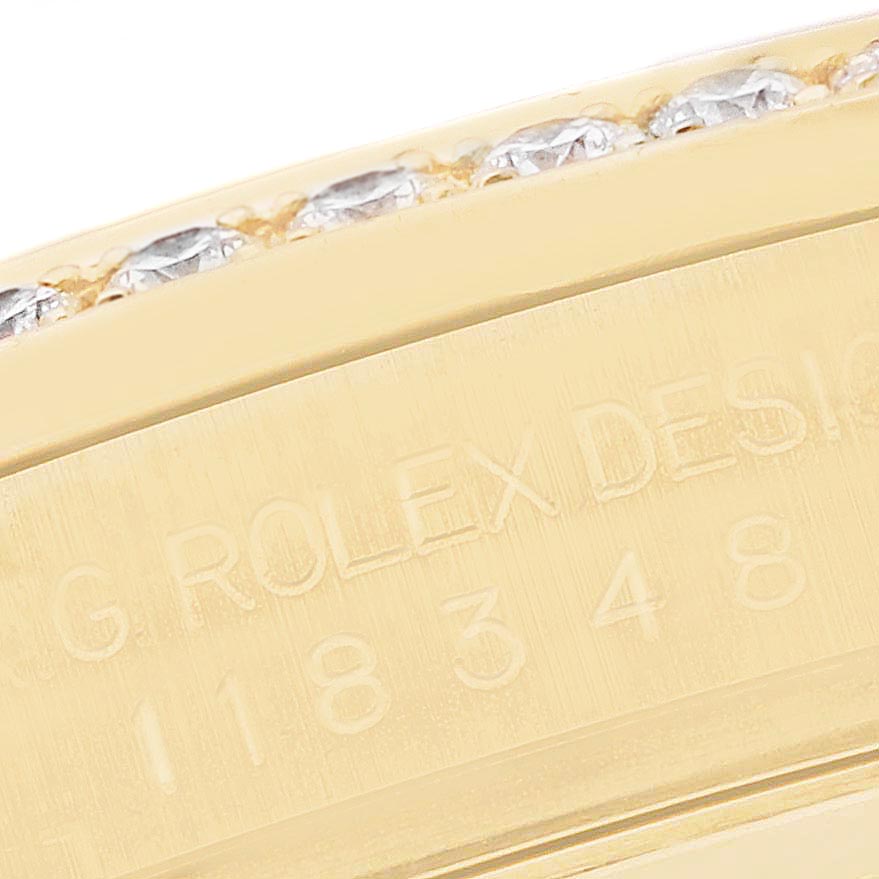 This image shows a close-up of the Rolex President 118348 Men's Yellow Gold Mother of Pearl Dial 118348 Men's Yellow Gold Mother of Pearl Dial model's engraved bezel, featuring a gold finish and diamond accents.