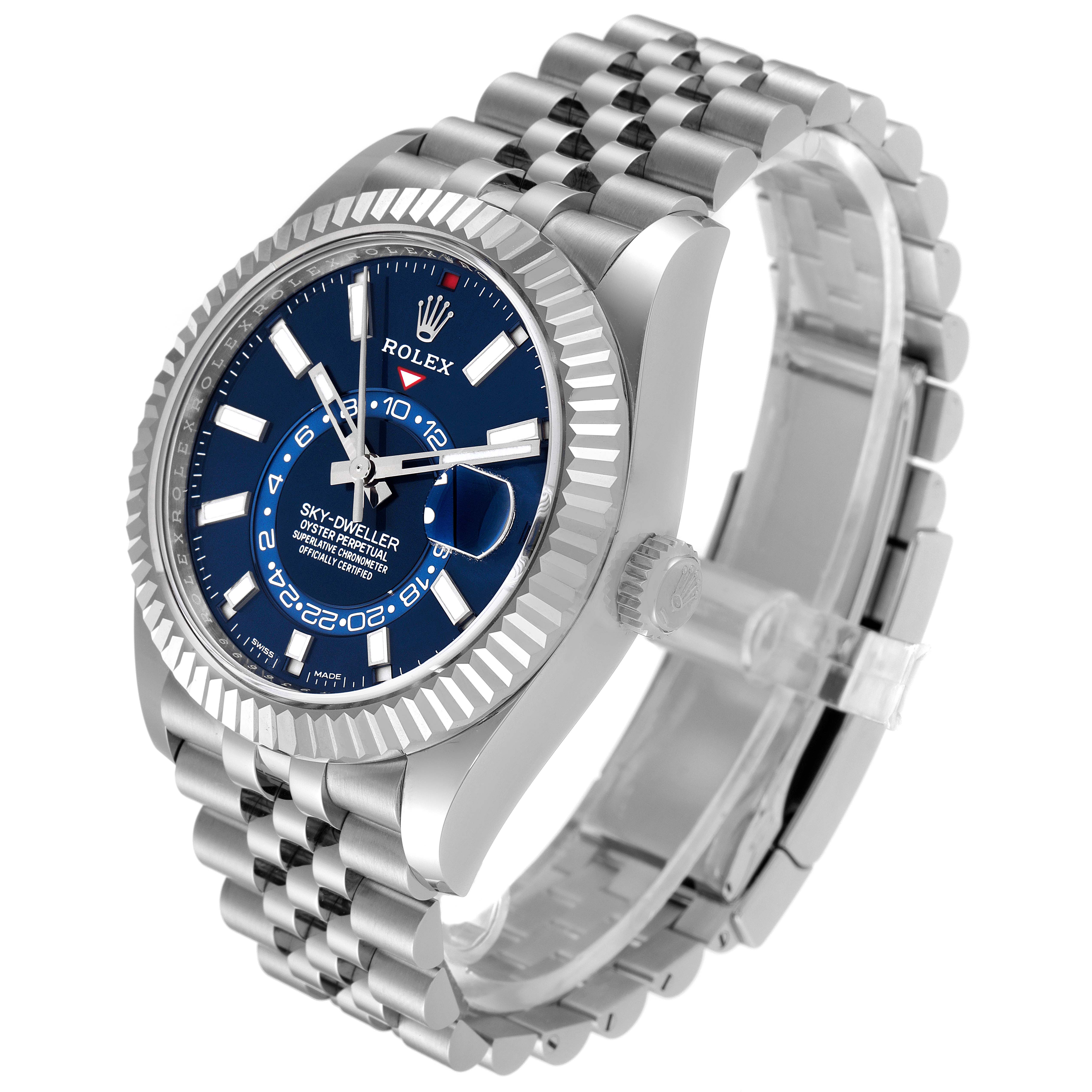 The Sky-Dweller model by Rolex is shown at an angle displaying the blue dial, fluted bezel, and Jubilee bracelet.