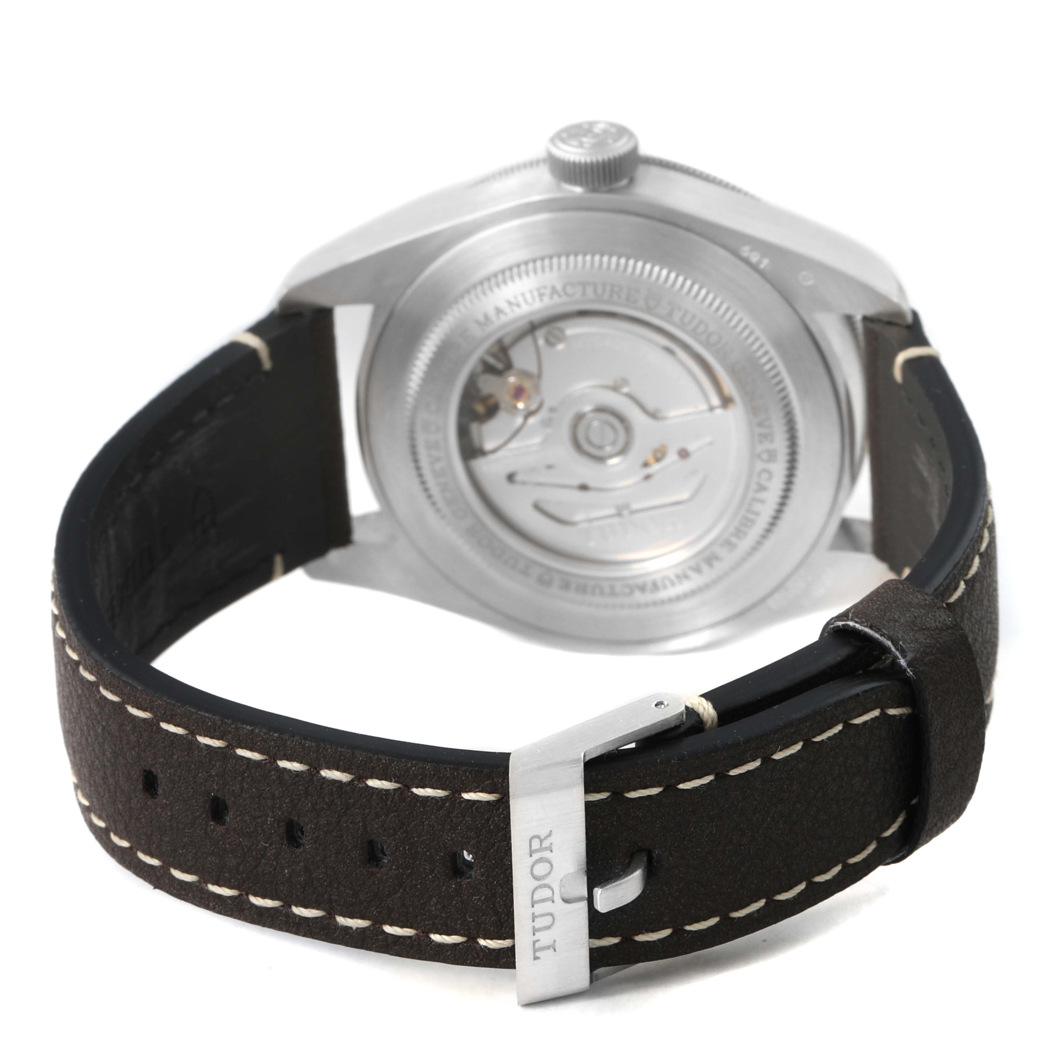 The image shows the back of the Tudor Heritage Black Bay M79010SG-0001 Men's Stainless Steel Grey Dial watch, focusing on the open caseback and leather strap.