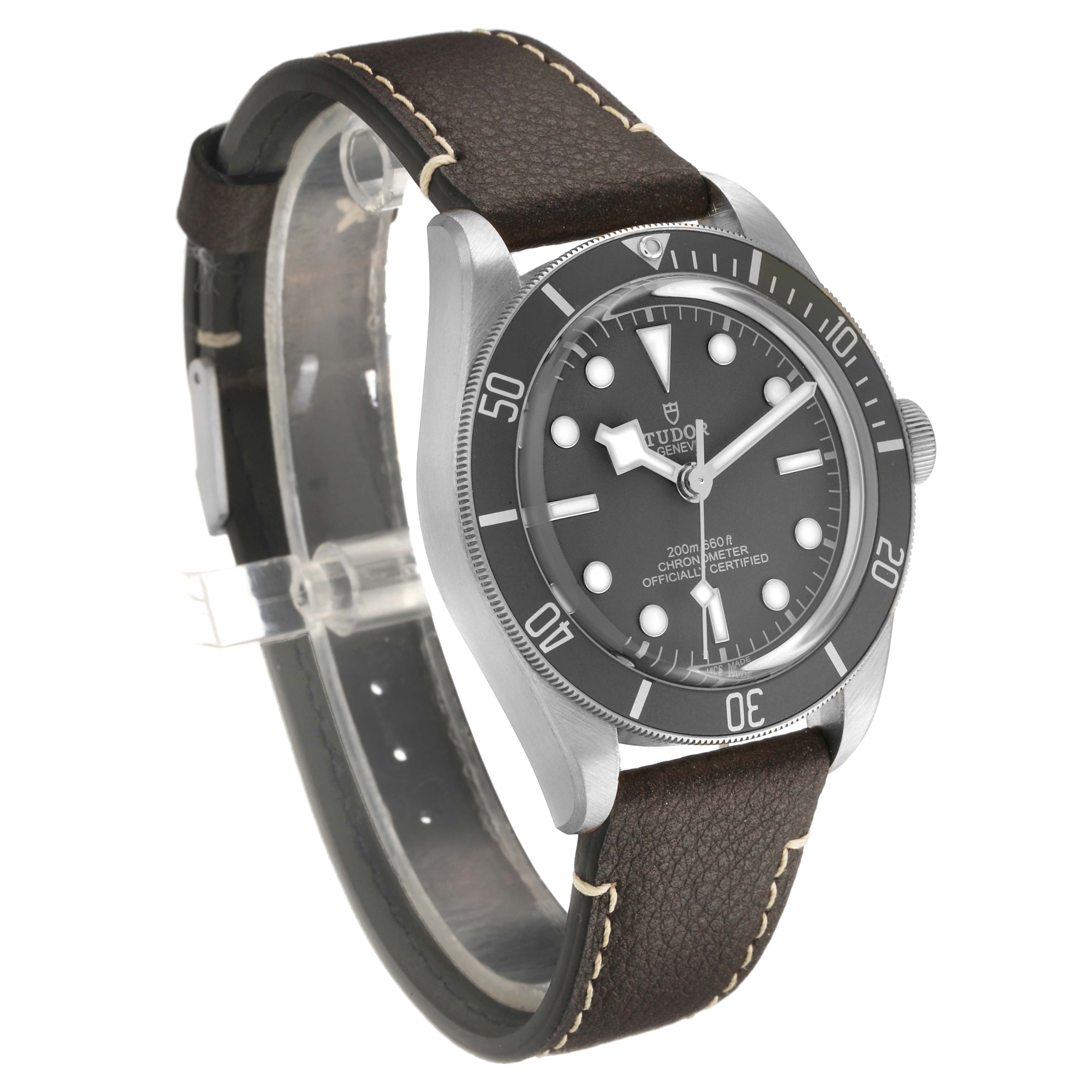 The Tudor Heritage Black Bay M79010SG-0001 Men's Stainless Steel Grey Dial watch is shown at a three-quarter angle, highlighting the face, bezel, crown, and leather strap.