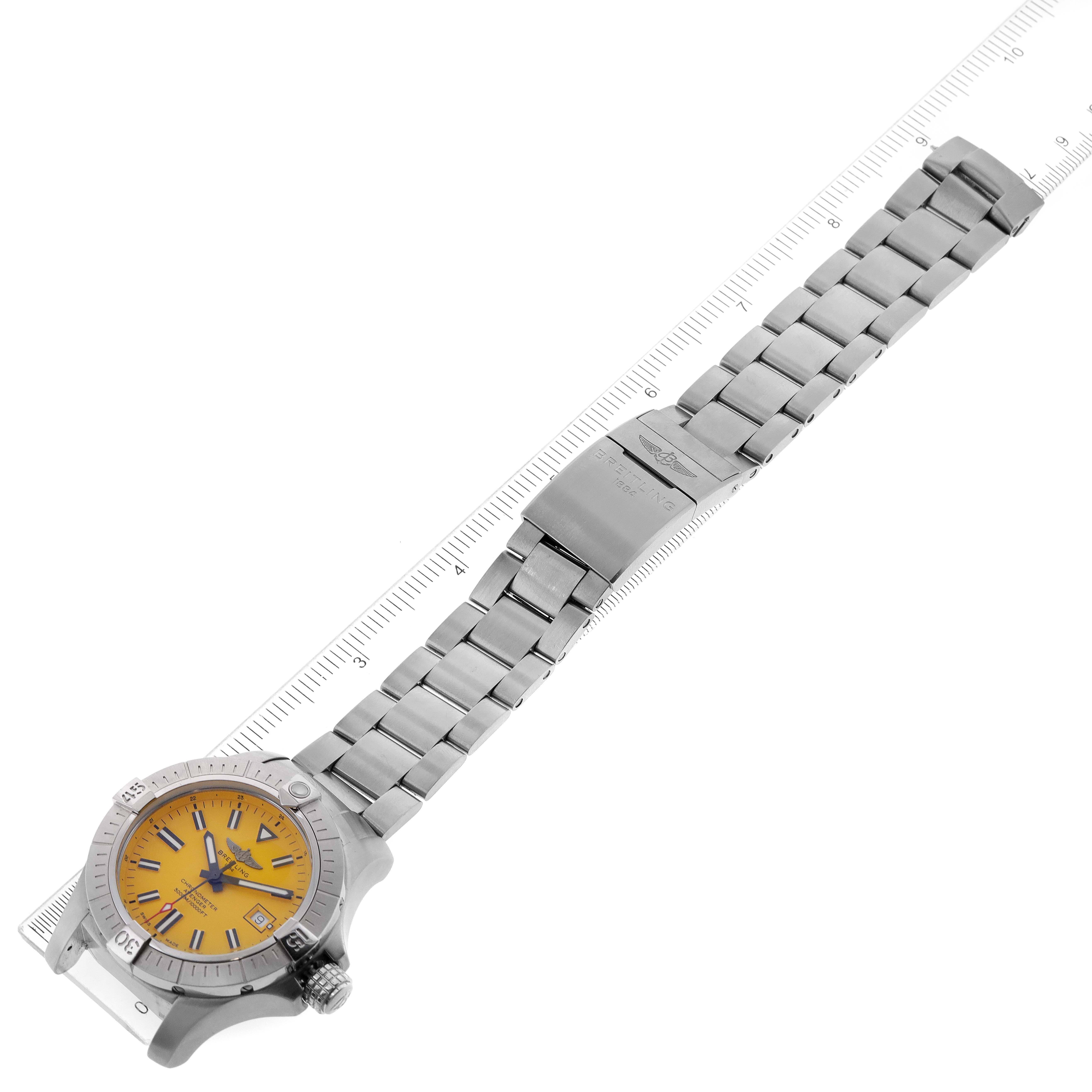 The image shows a top-down view of a Breitling Avenger A17319 Men
s Stainless Steel Yellow Dial A17319 Men
s Stainless Steel Yellow Dial watch with a stainless steel bracelet and a yellow dial, measured against a ruler.