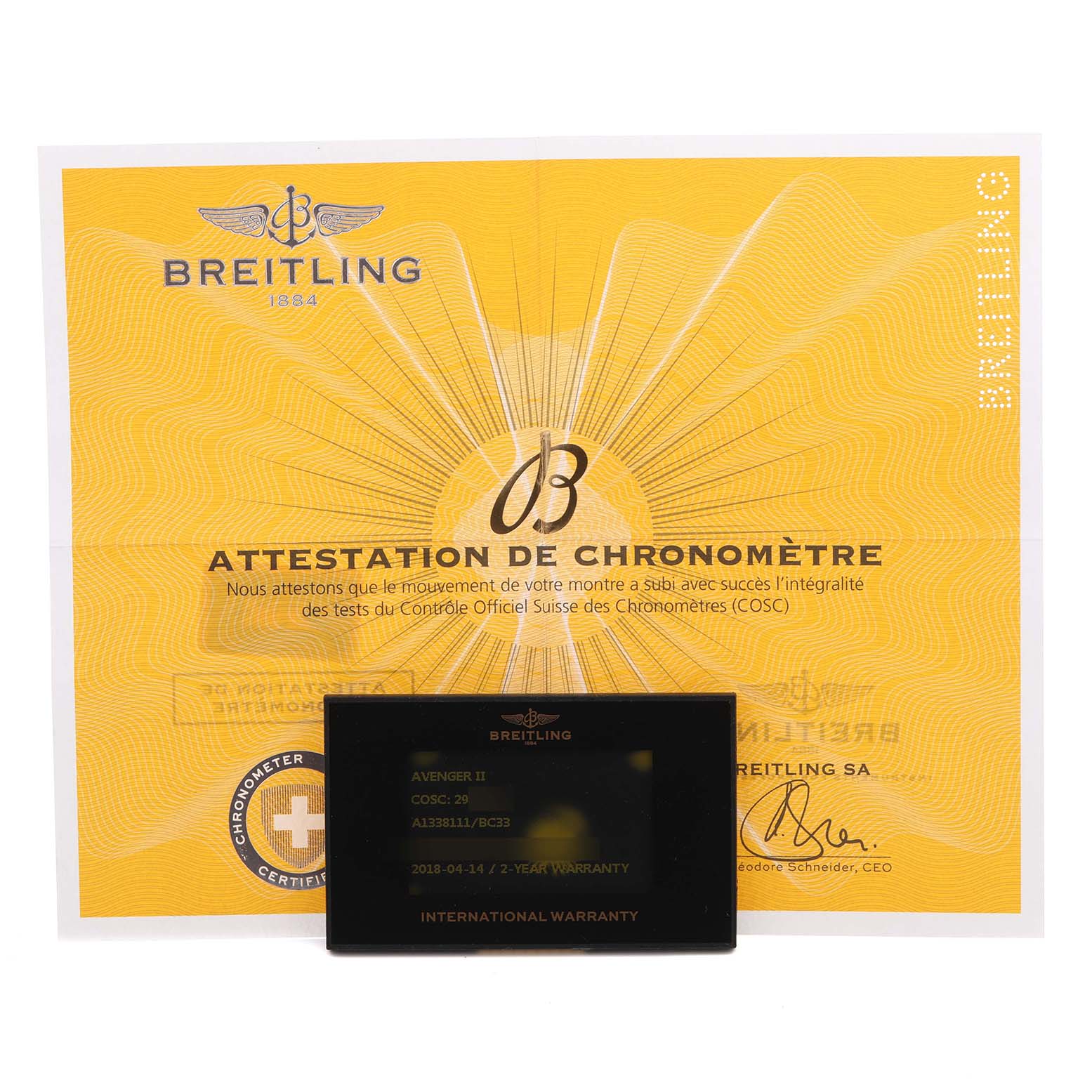 The image shows a Breitling Avenger A1338111/BC33 Men's Stainless Steel Black Dial A1338111/BC33 Men's Stainless Steel Black Dial model warranty card and a certificate of chronometer against a yellow background.