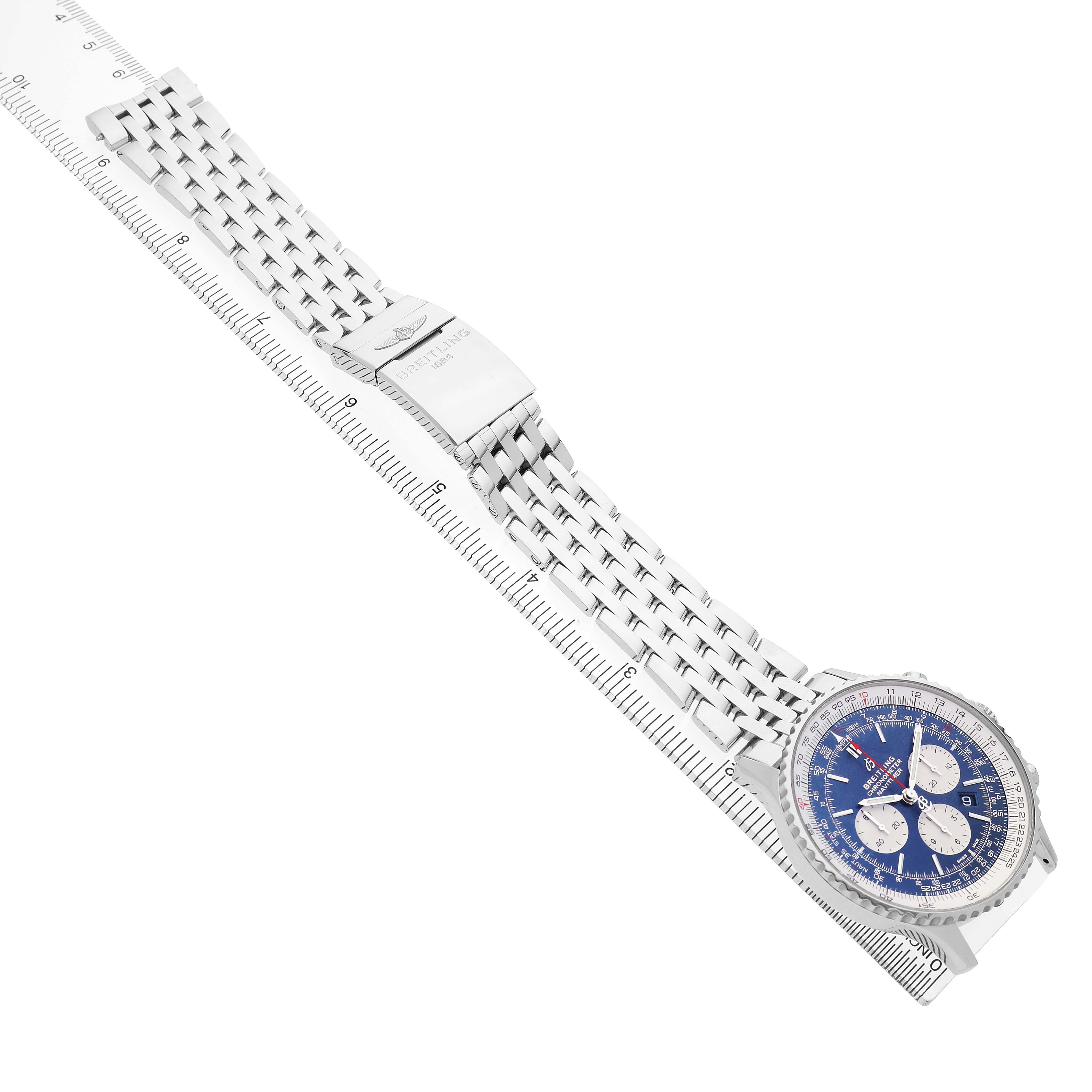 The Breitling Navitimer AB0127211C2A1 Men's Stainless Steel Blue Dial watch is shown at an angle, displaying the face, metal bracelet, and clasp on a ruler.