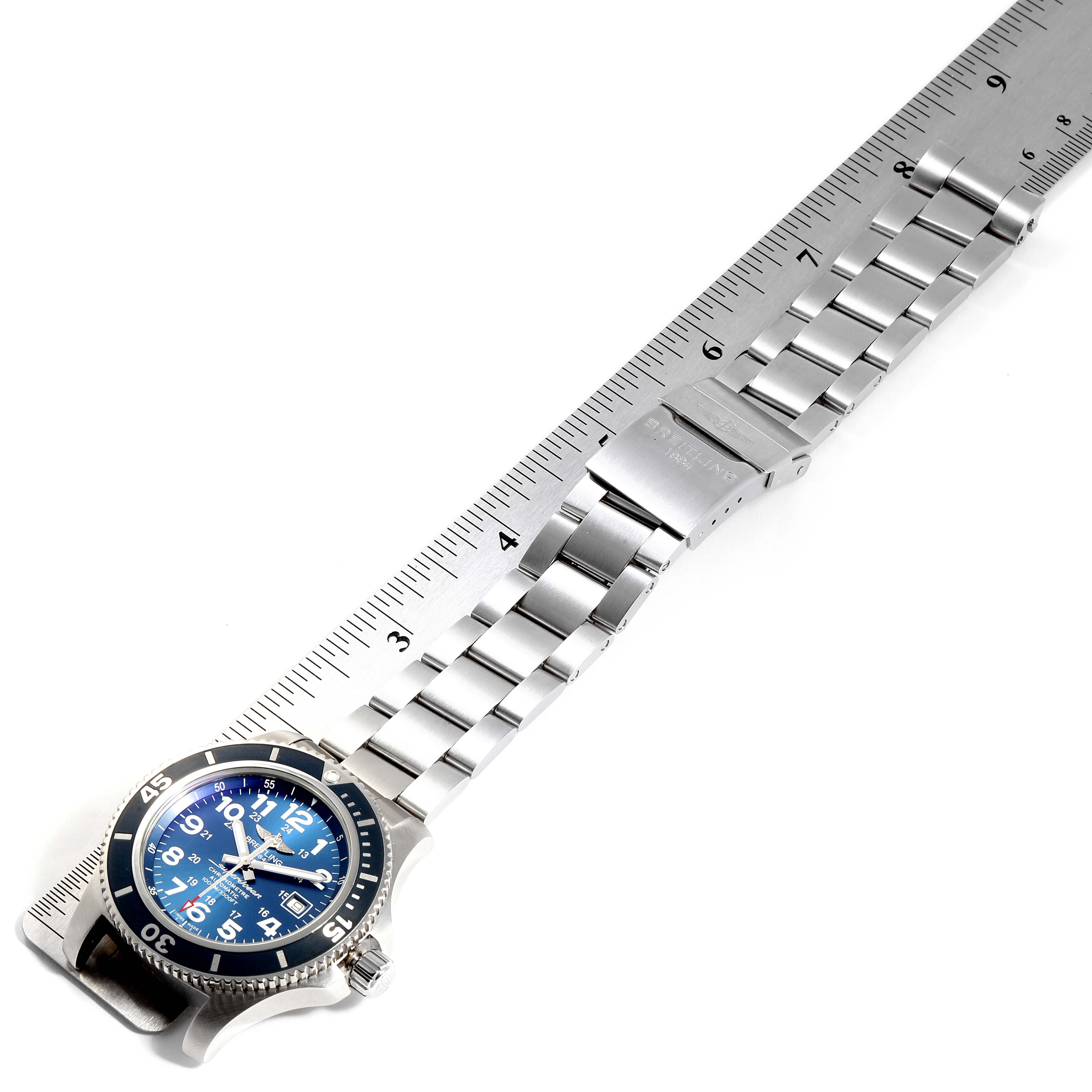 The image shows a top-down view of a Breitling Superocean A17392D8/C910  Men's Stainless Steel Blue Dial A17392D8/C910  Men's Stainless Steel Blue Dial watch with a stainless steel bracelet and a blue dial, measured against a ruler.