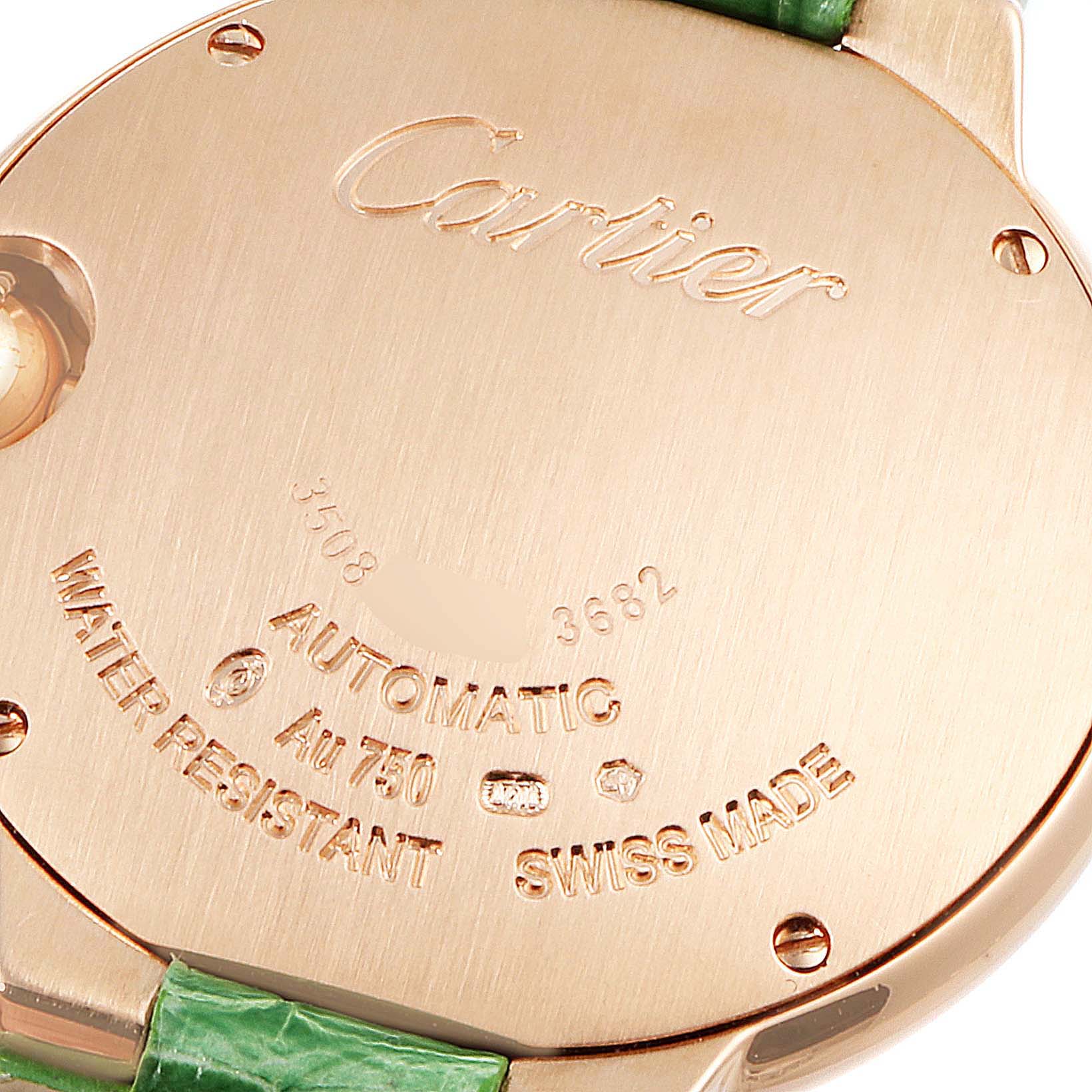 This image shows the back of a Cartier Ballon Bleu W6920097 Women's Rose Gold Silver Dial W6920097 Women's Rose Gold Silver Dial watch, highlighting the engravings and part of the green strap.