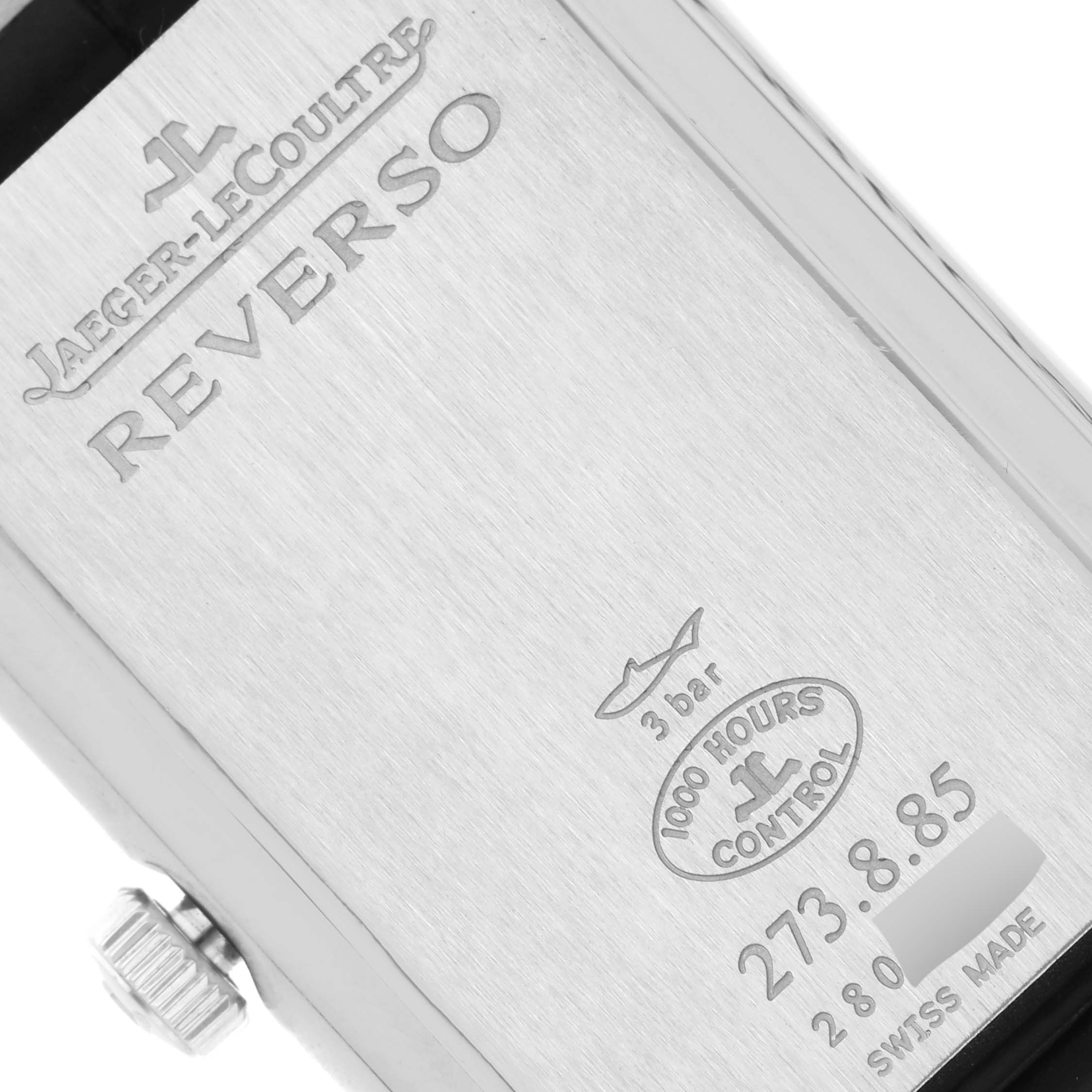 The image shows a close-up of the back case of a Jaeger LeCoultre Reverso Q3748421 Men's Stainless Steel Silver Dial Q3748421 Men's Stainless Steel Silver Dial watch, including engravings and the crown.