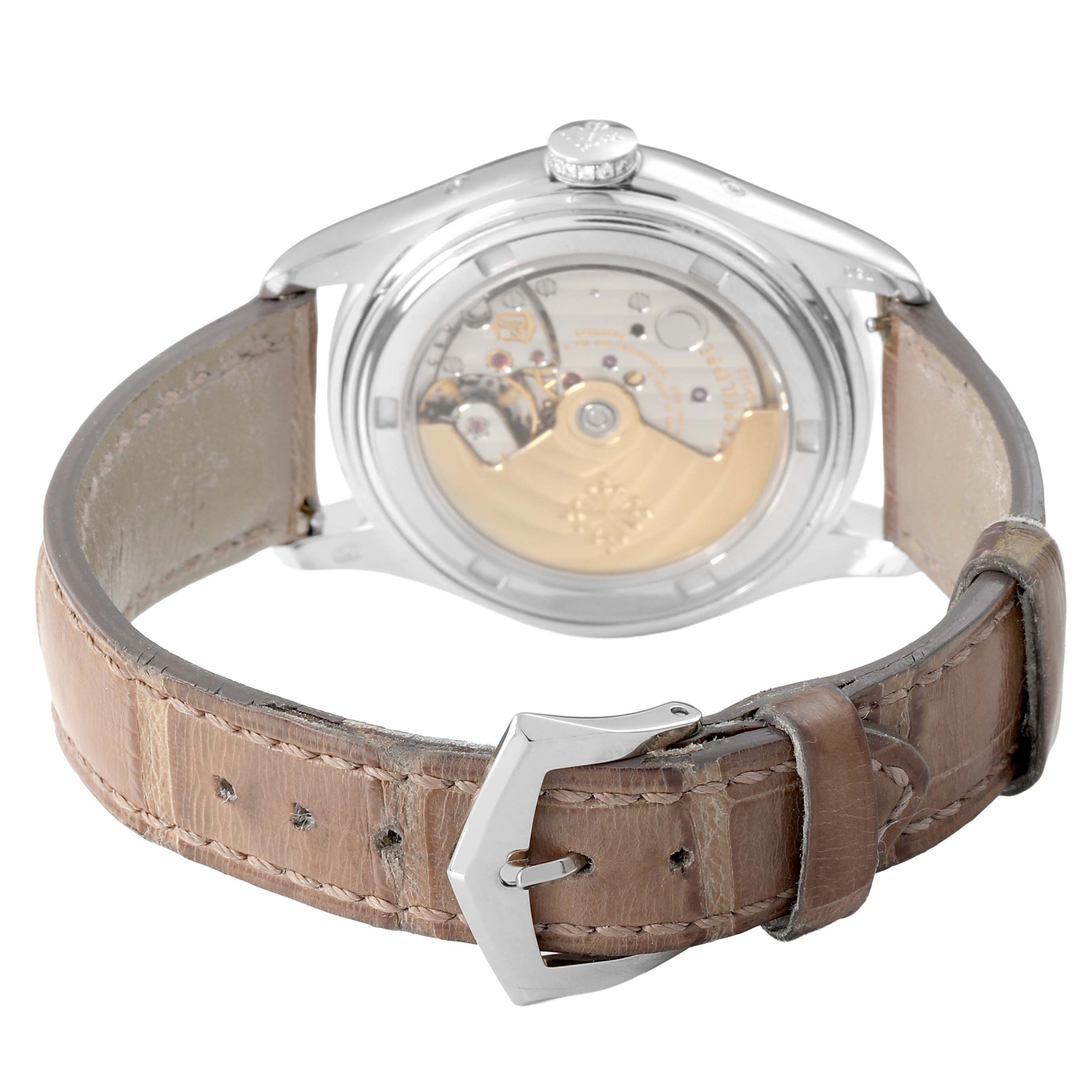 The image shows the back view of a Patek Philippe Complications 4936G - 001 Men's White Gold Mother of Pearl Dial watch, highlighting the movement and tan leather strap.