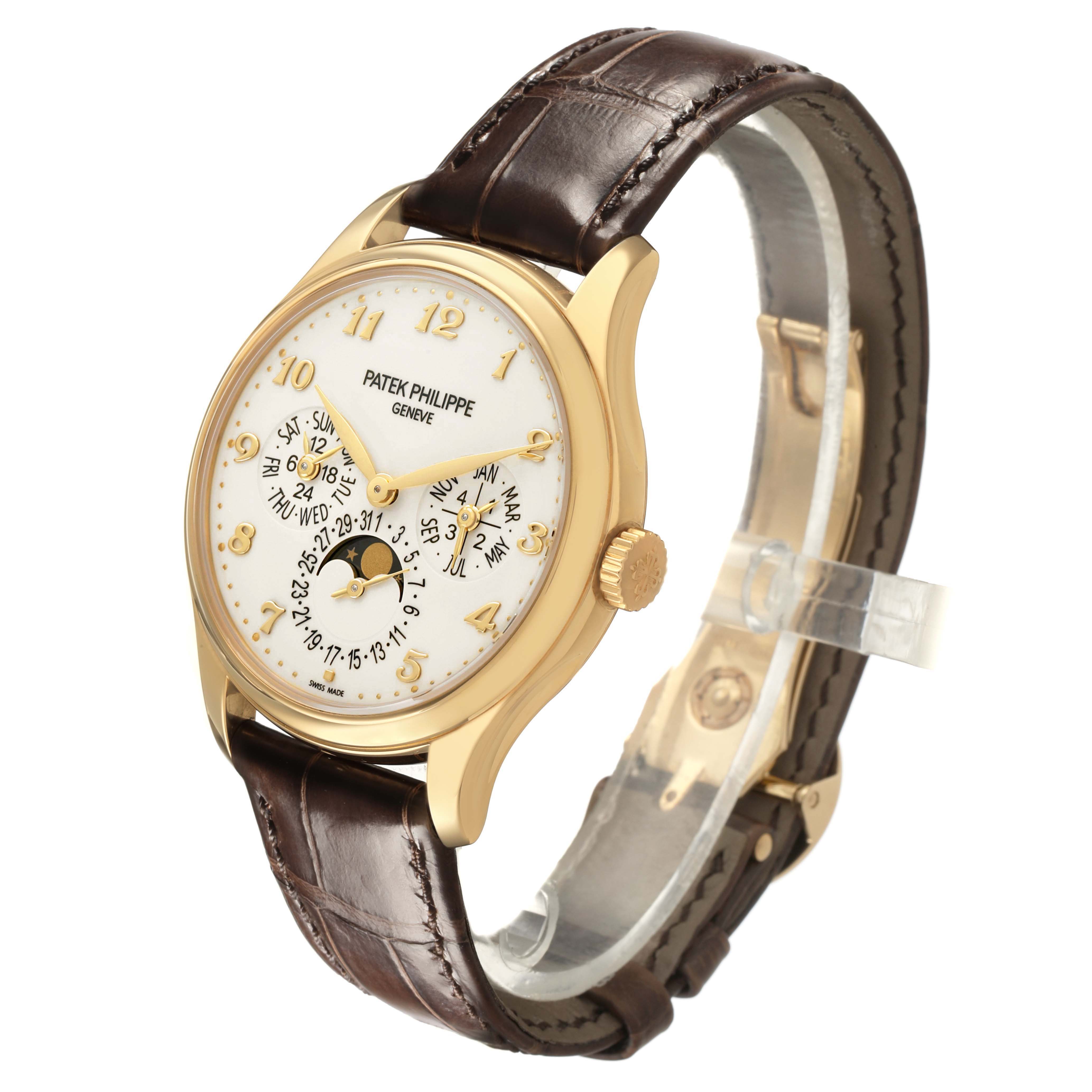 The Patek Philippe Complications 5327J-001 Men's Yellow Gold Beige Dial watch is shown at a three-quarter angle, highlighting the face, gold case, crown, and brown leather strap.