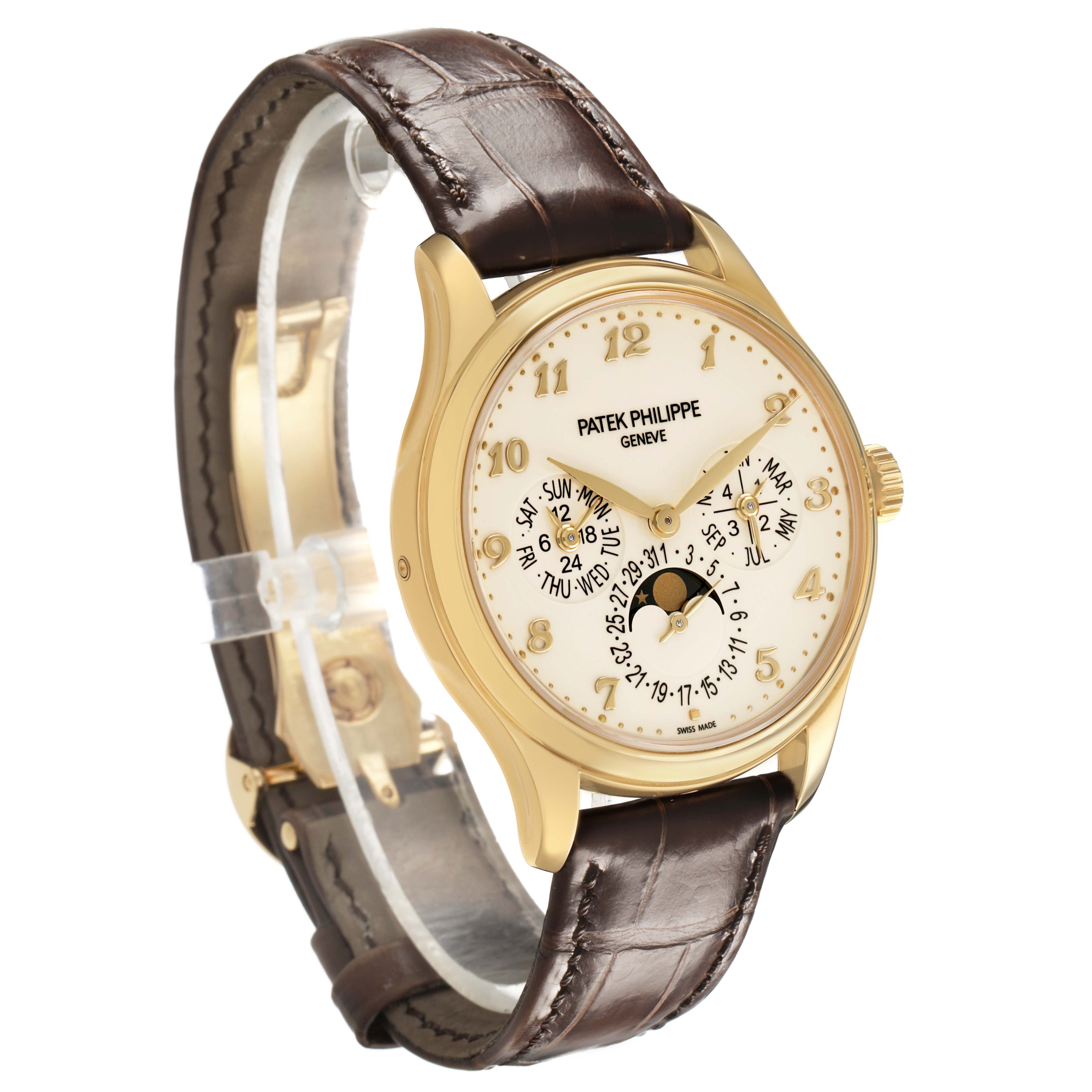 The Patek Philippe Complications 5327J-001 Men's Yellow Gold Beige Dial watch is shown from a three-quarter angle, displaying the face, gold case, and leather strap.